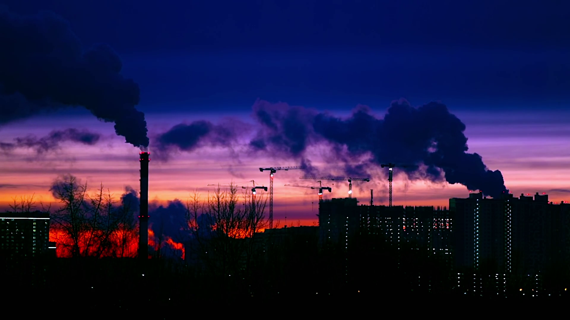 Modern city in the evening at sunset. Smoke comes out of the pipes ...