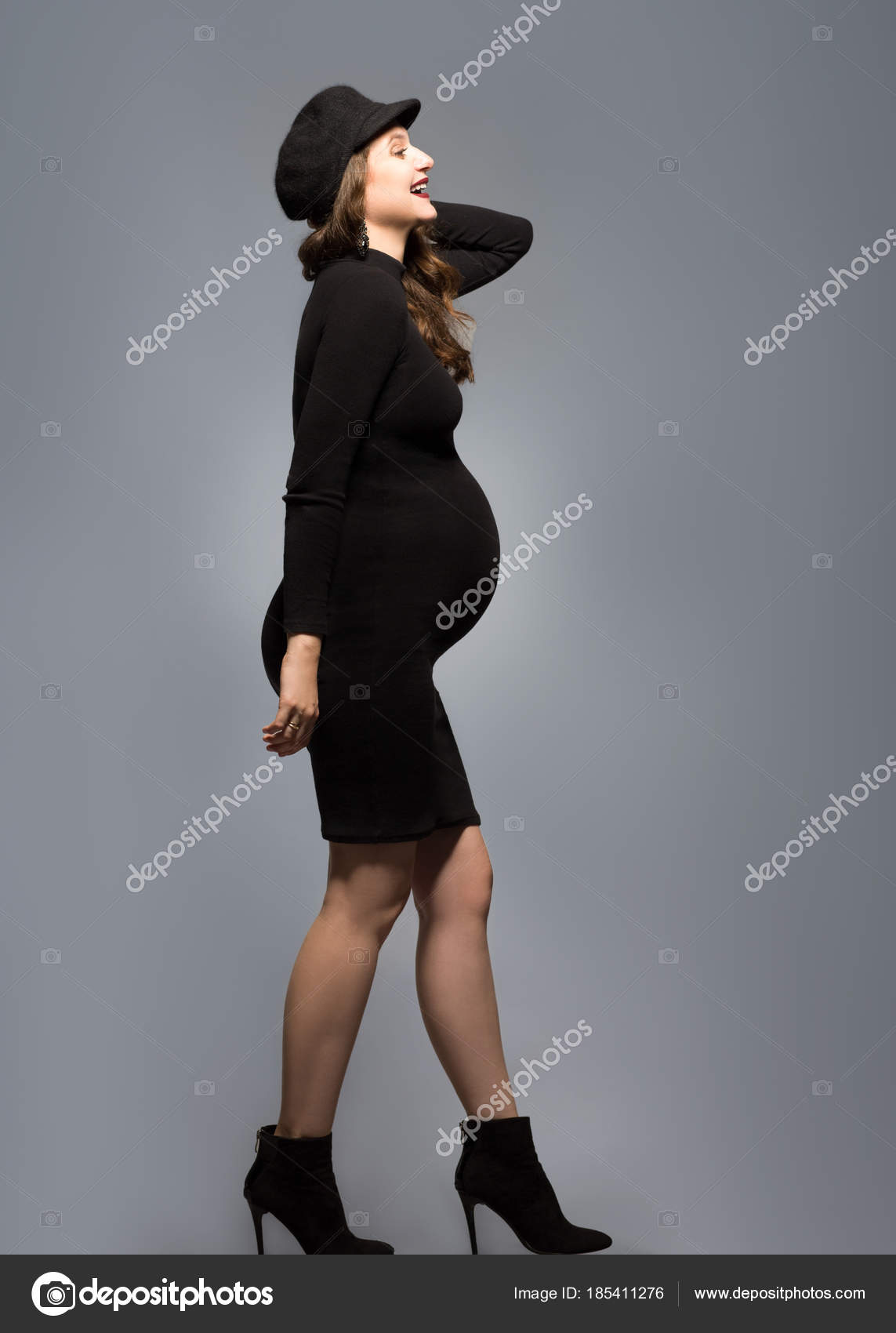 beautiful fashionable girl pregnant in studio stands posing — Stock ...