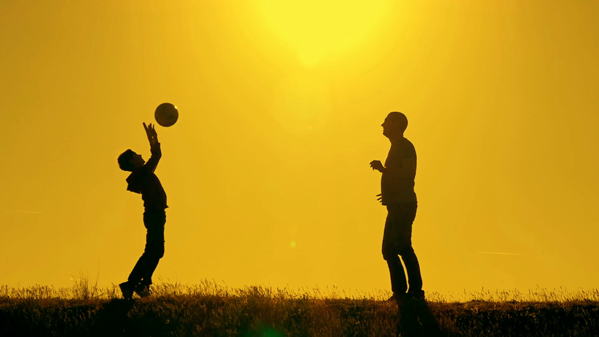 Father and son playing football in the park at sunset, silhouettes ...
