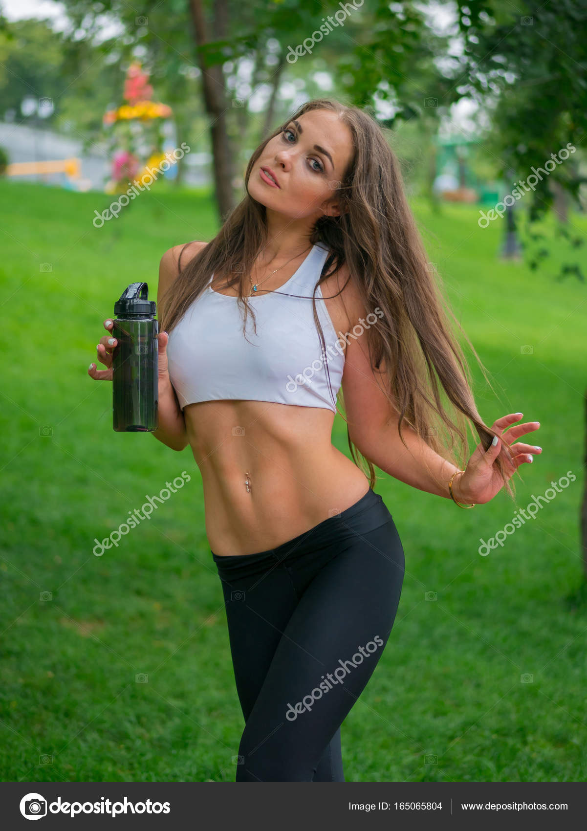 Thirsty female jogger drinking fresh water after training. Young ...