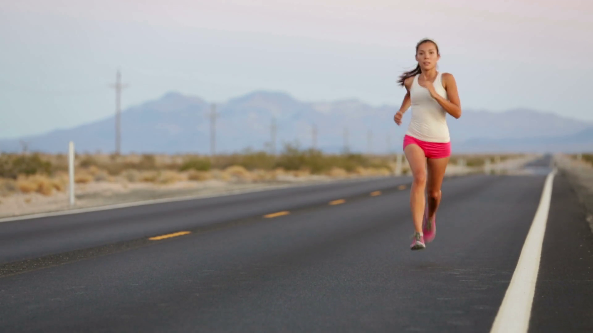 Woman runner running on open road in countryside. Female jogger ...