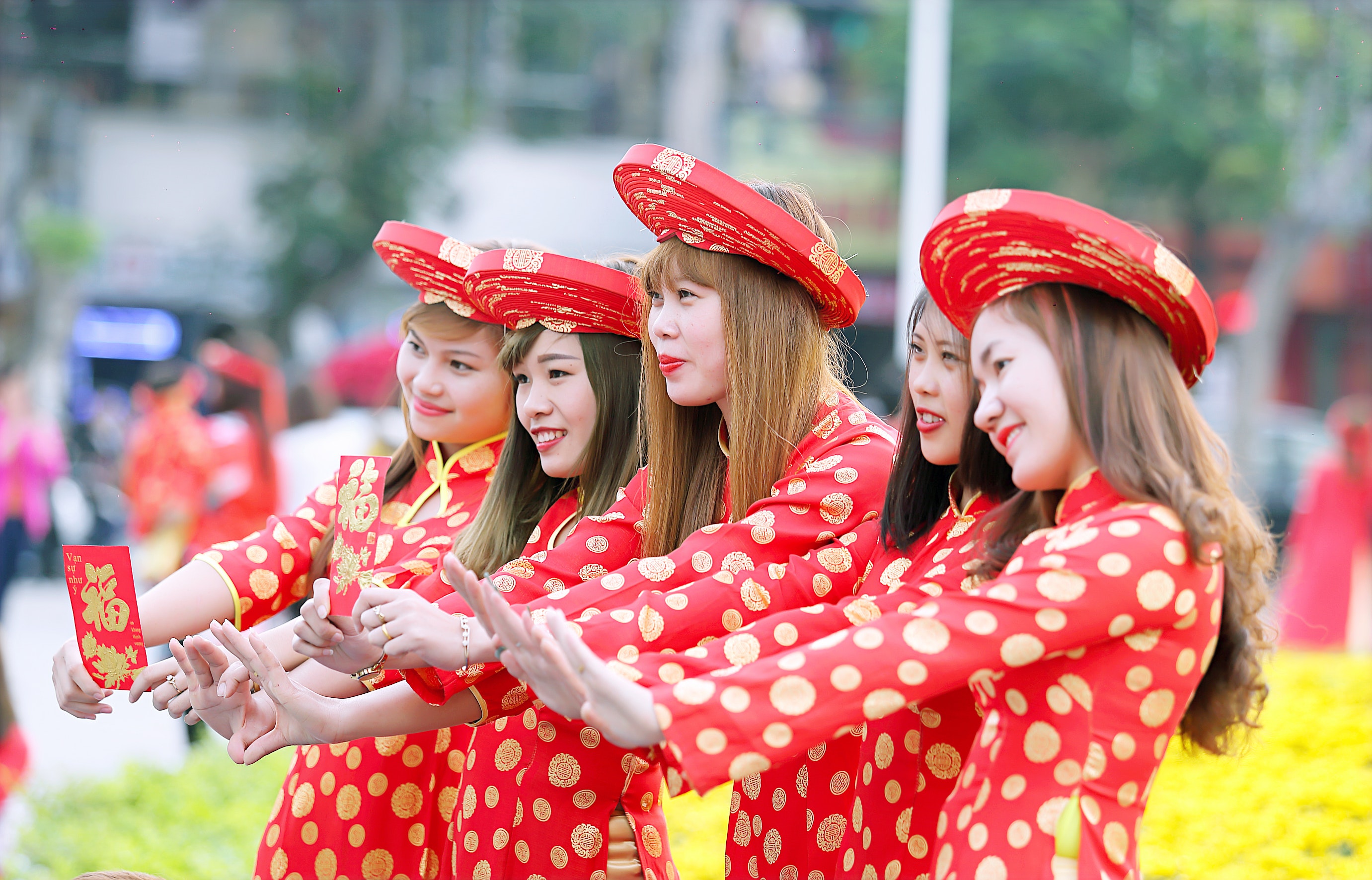 Five women in red and white polka dot cheongsam dress standing photo