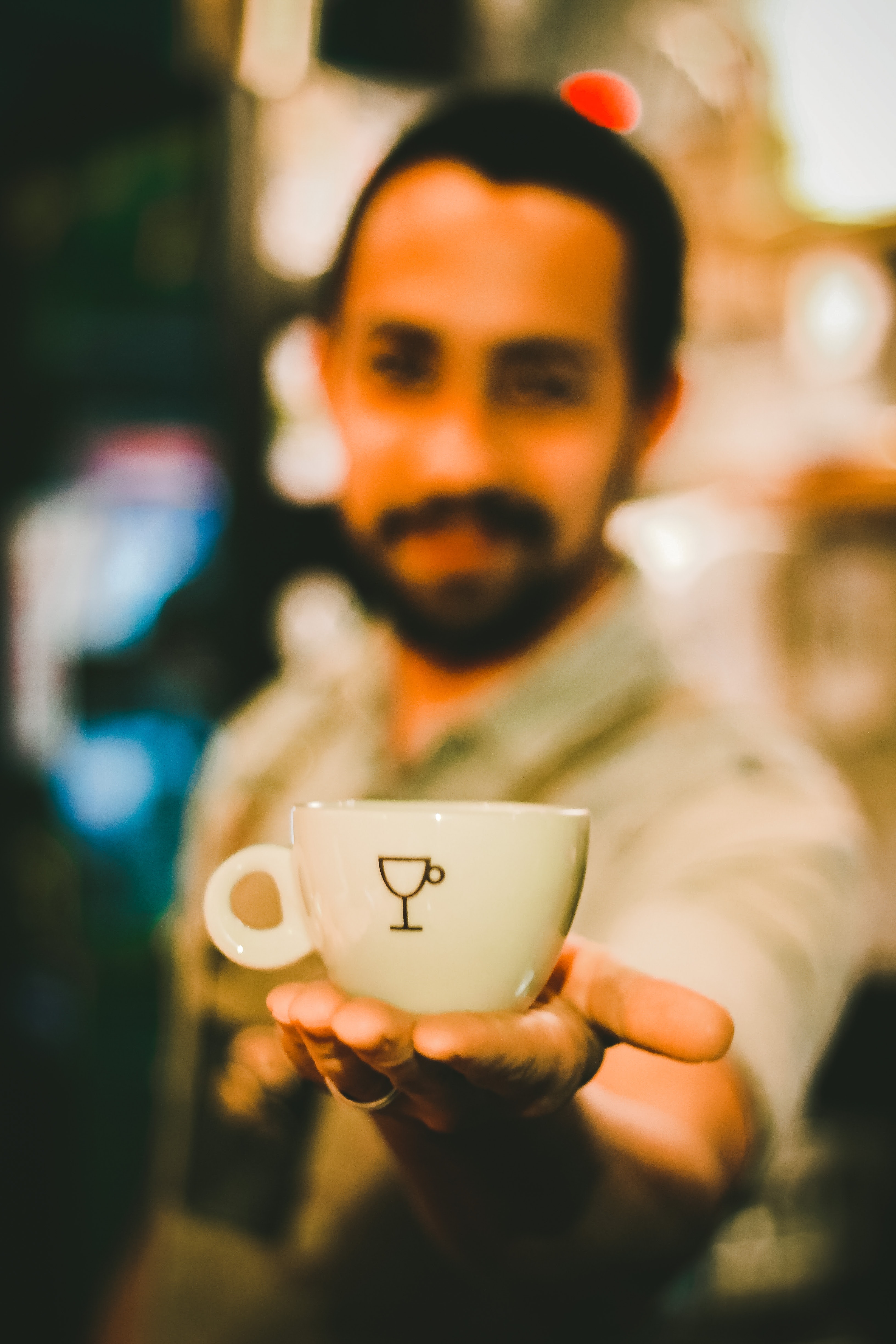 Focus photography of man holding ceramic teacup
