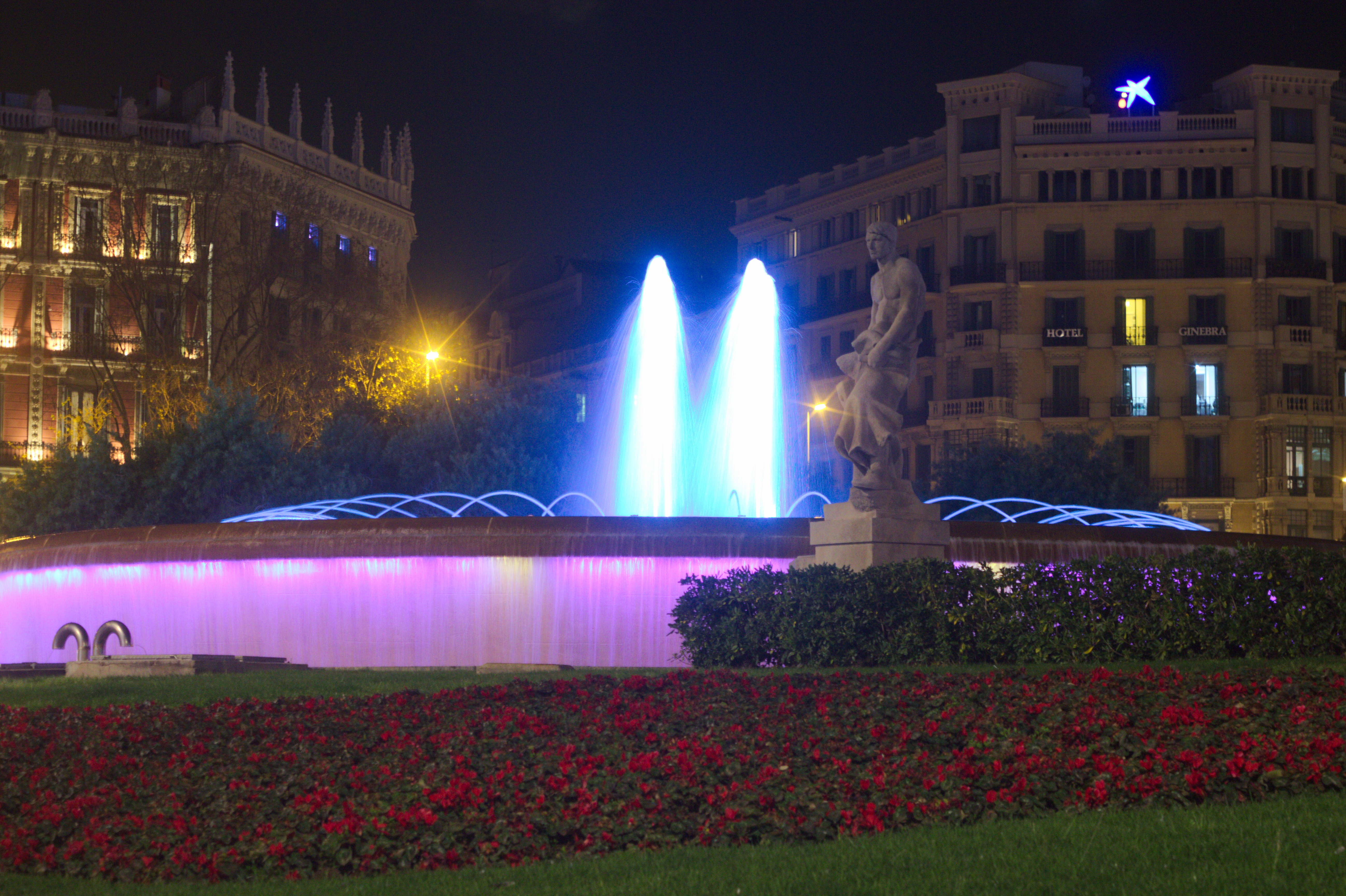 Fountain and statue at night on plaça de catalunya photo
