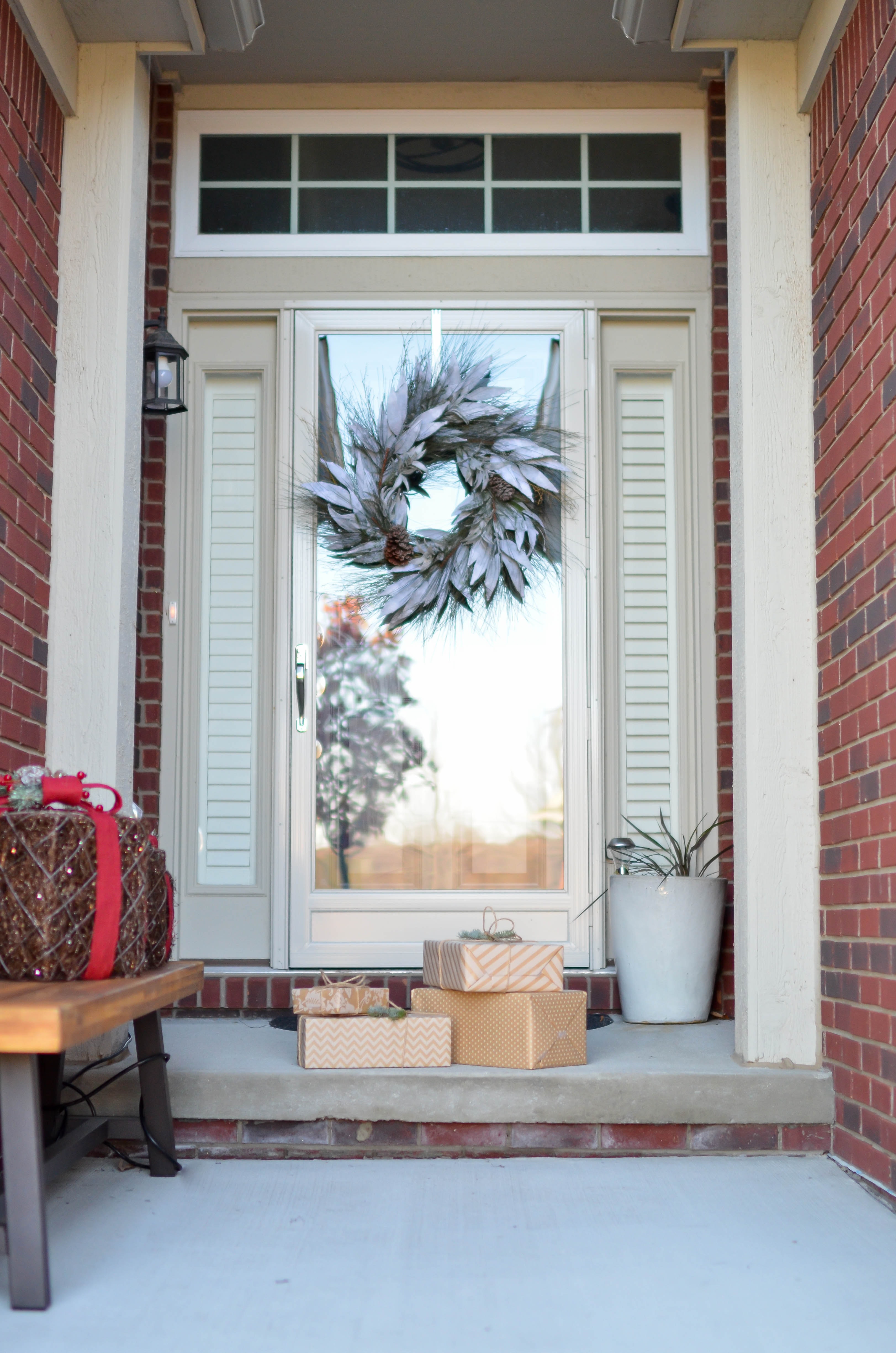 Four brown gift boxes near a glass paneled door with wreath photo