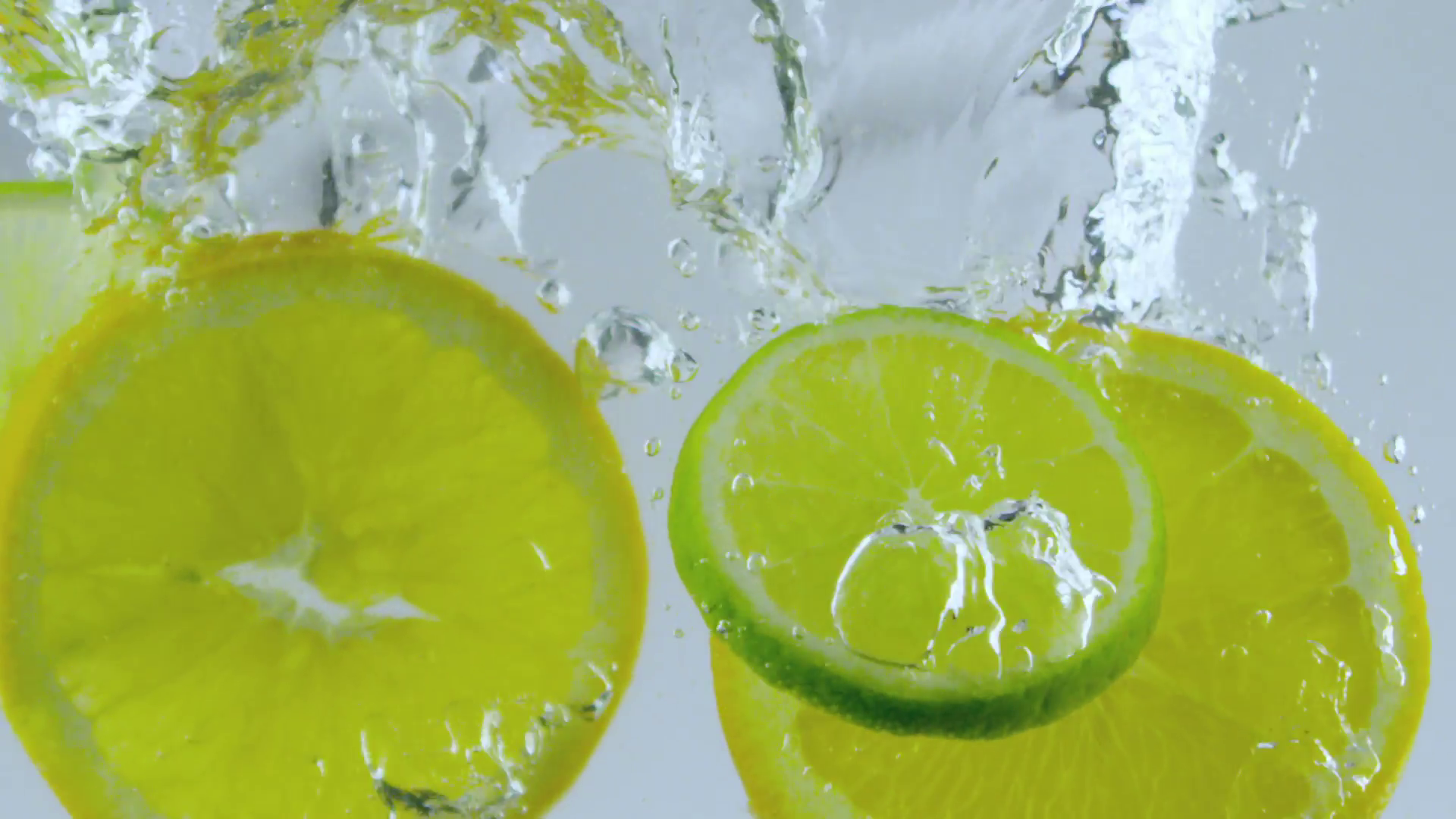 fresh lemons and limes falling in slow motion inside water Stock ...