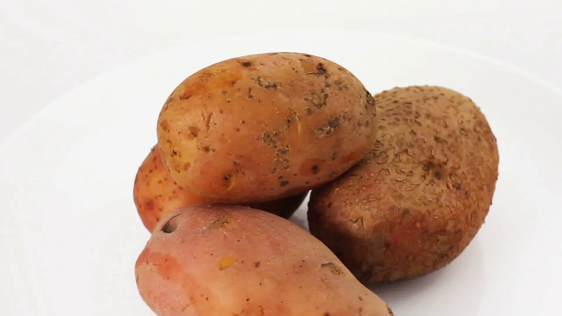 Video of fresh potatoes rotating at white background. Vegetable ...