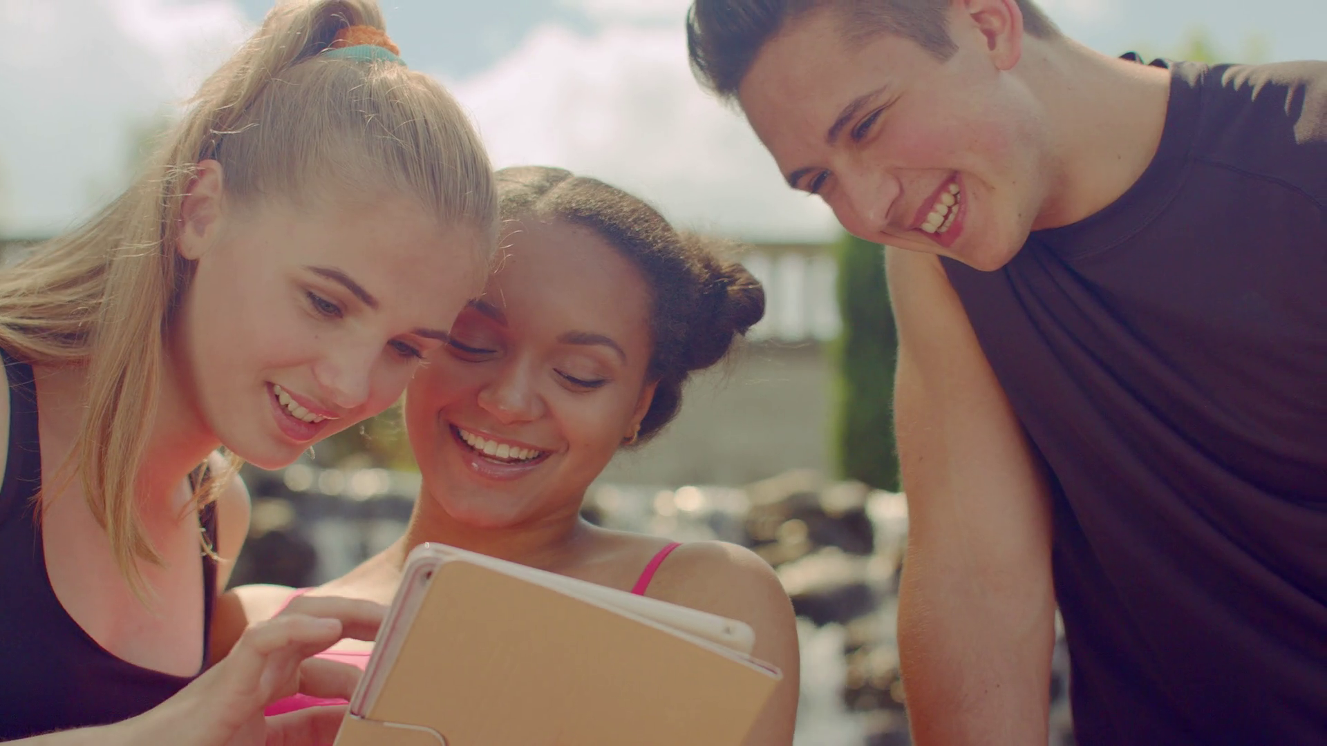 Happy friends surf internet on tablet outdoor. Closeup of young ...