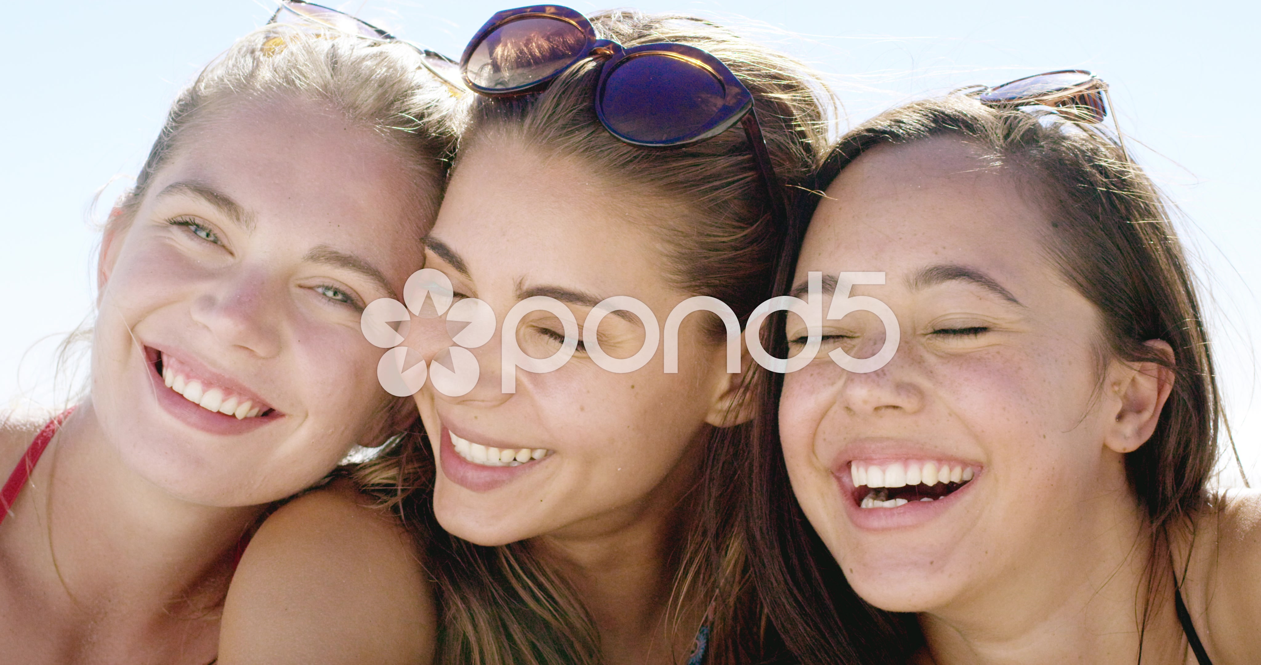 Close up portrait of three teenage girl friends smiling on tropical ...