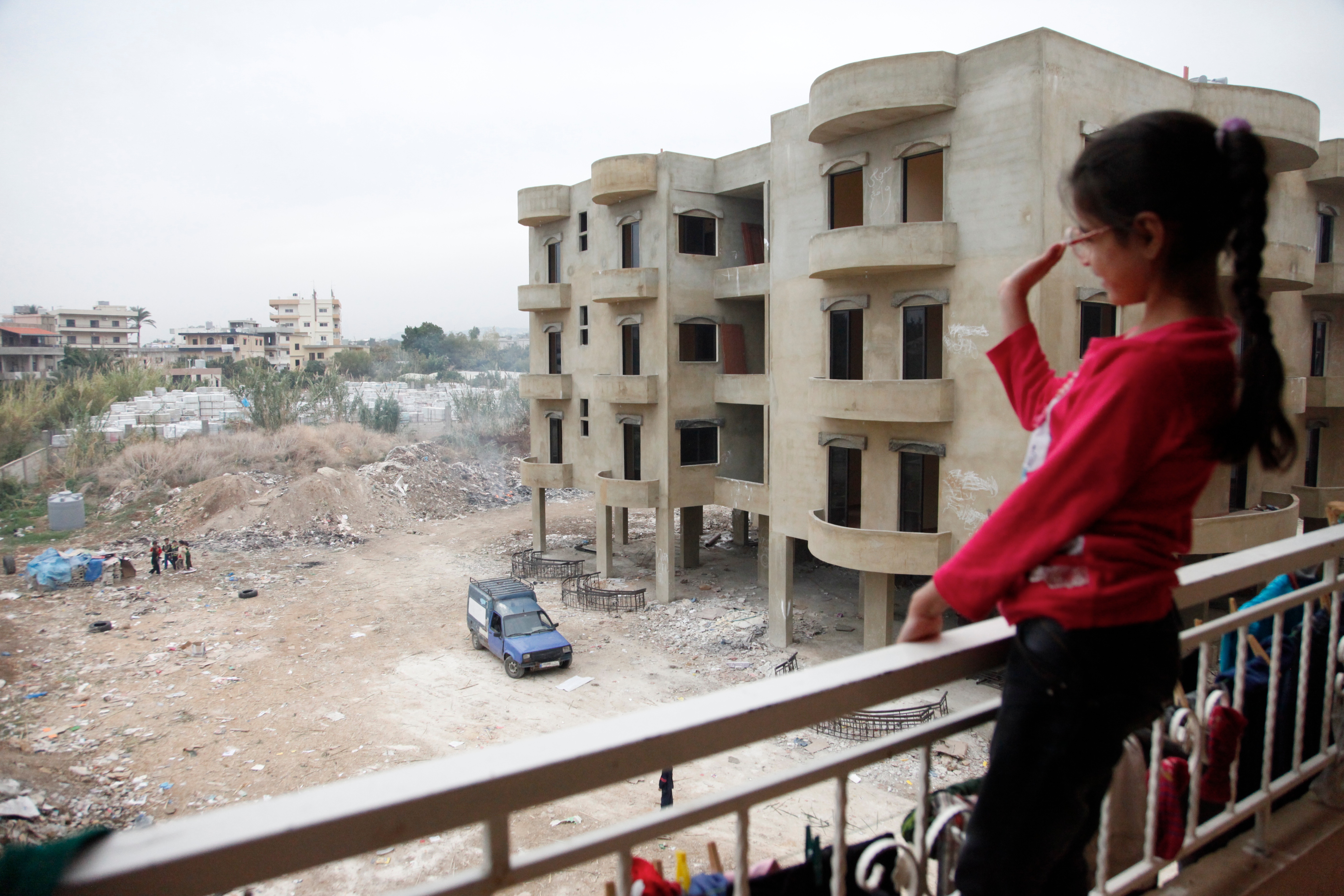 File:A Syrian girl waves from the balcony of an unfinished apartment ...