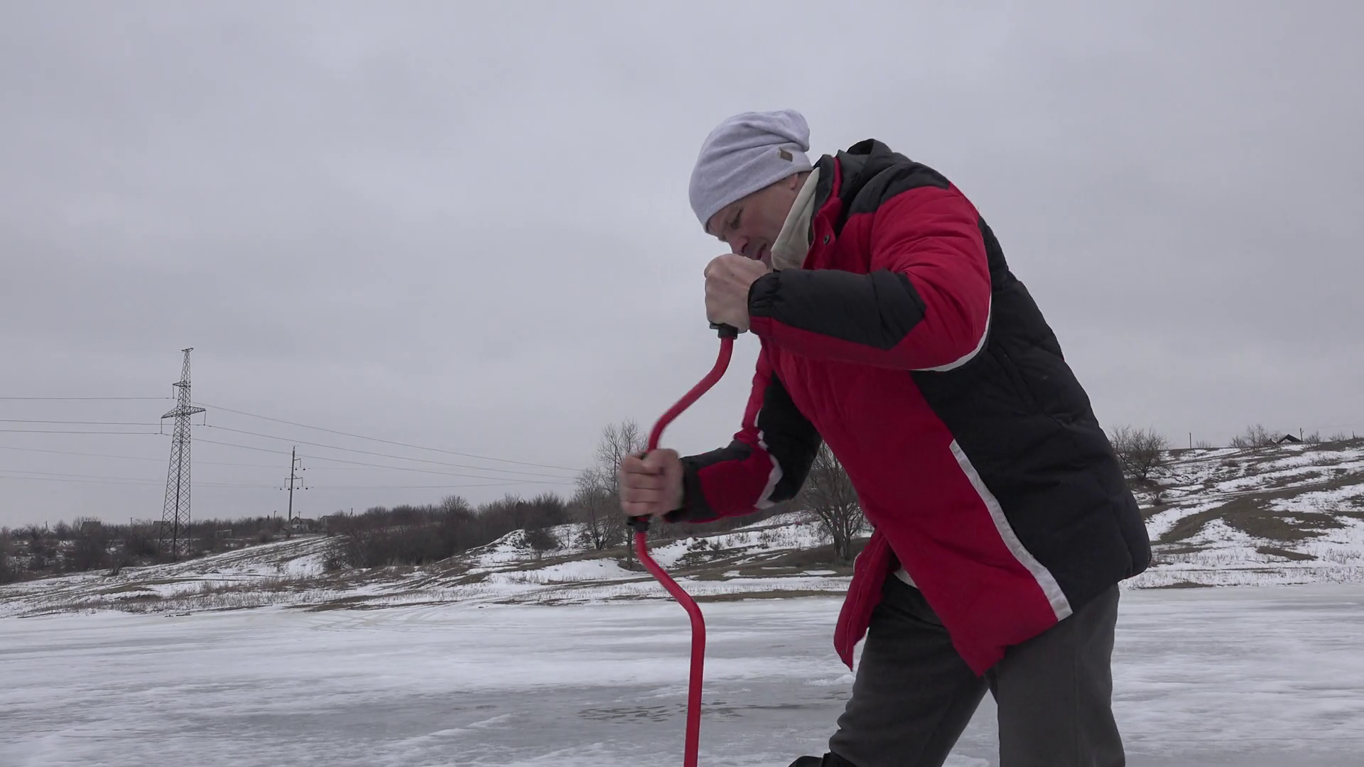 Fisherman drills hole in ice for winter fishing on frozen pond US 4k ...