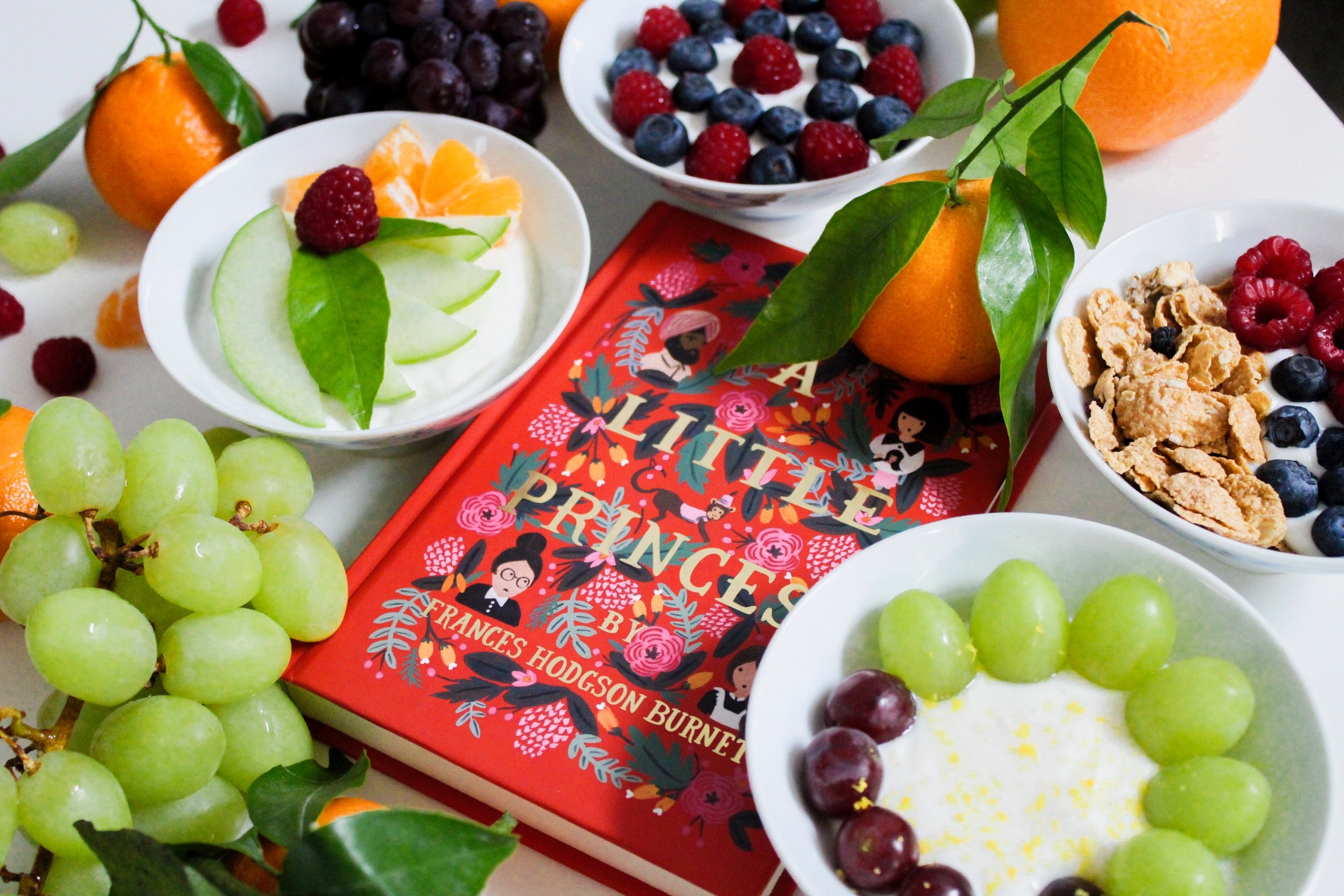 Fruits on plates beside red book photo
