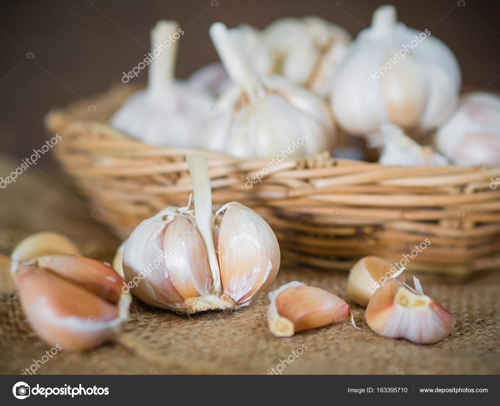 Closeup garlic clove, garlic bulb in wicker basket place on hemp ...