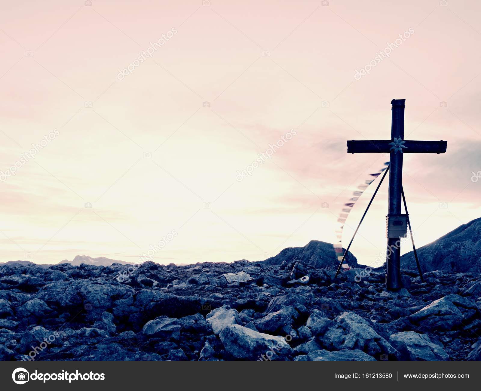 Modest wooden cross raised on rocky Alpine mountain summit . Sharp ...