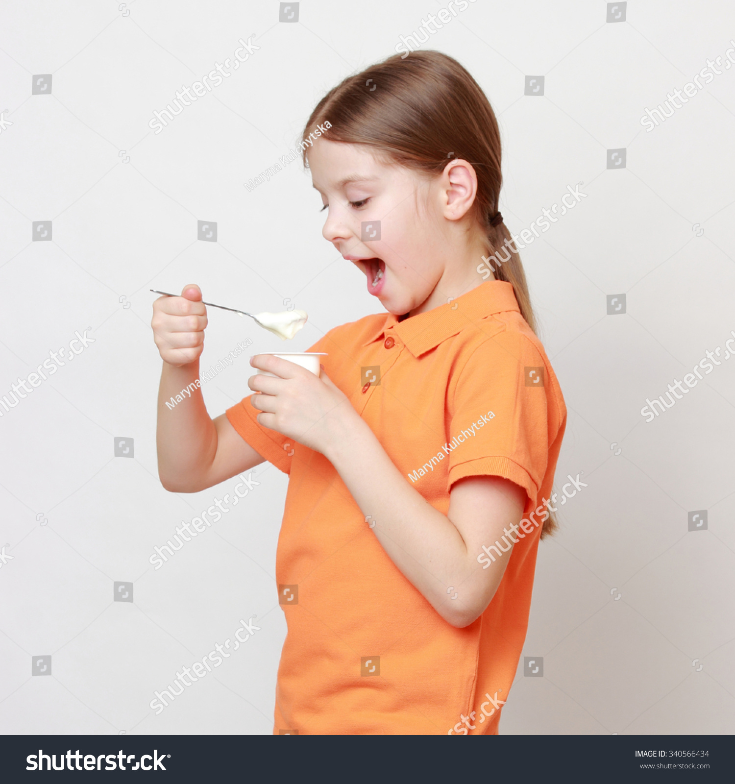 Lovely European Little Girl Eating Yoghurt Stock Photo (Download Now ...