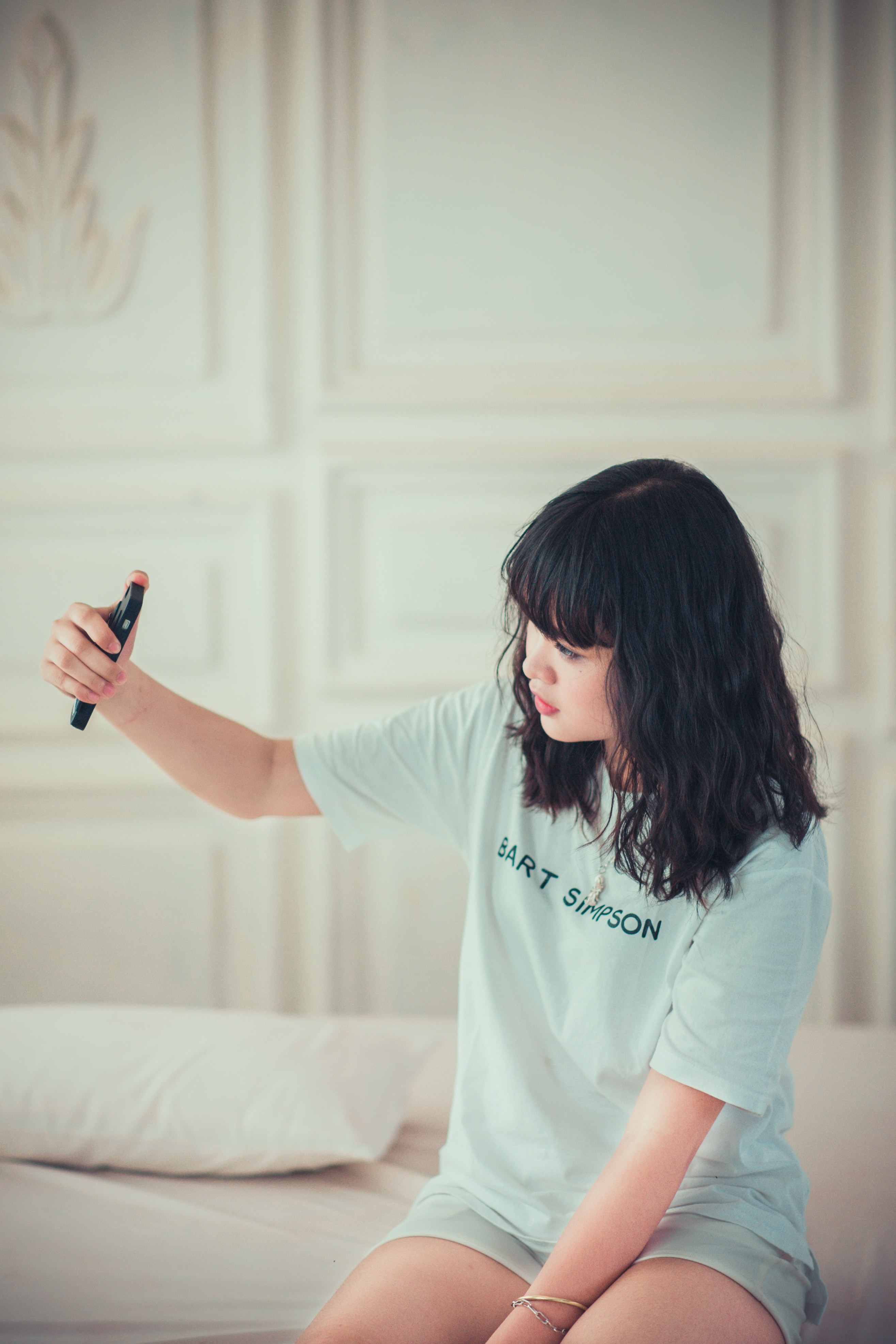 Girl in Blue Crew Neck Shirt Using Her Mobile Phone Indoors, Bed, Smile, Relax, Relaxation, HQ Photo