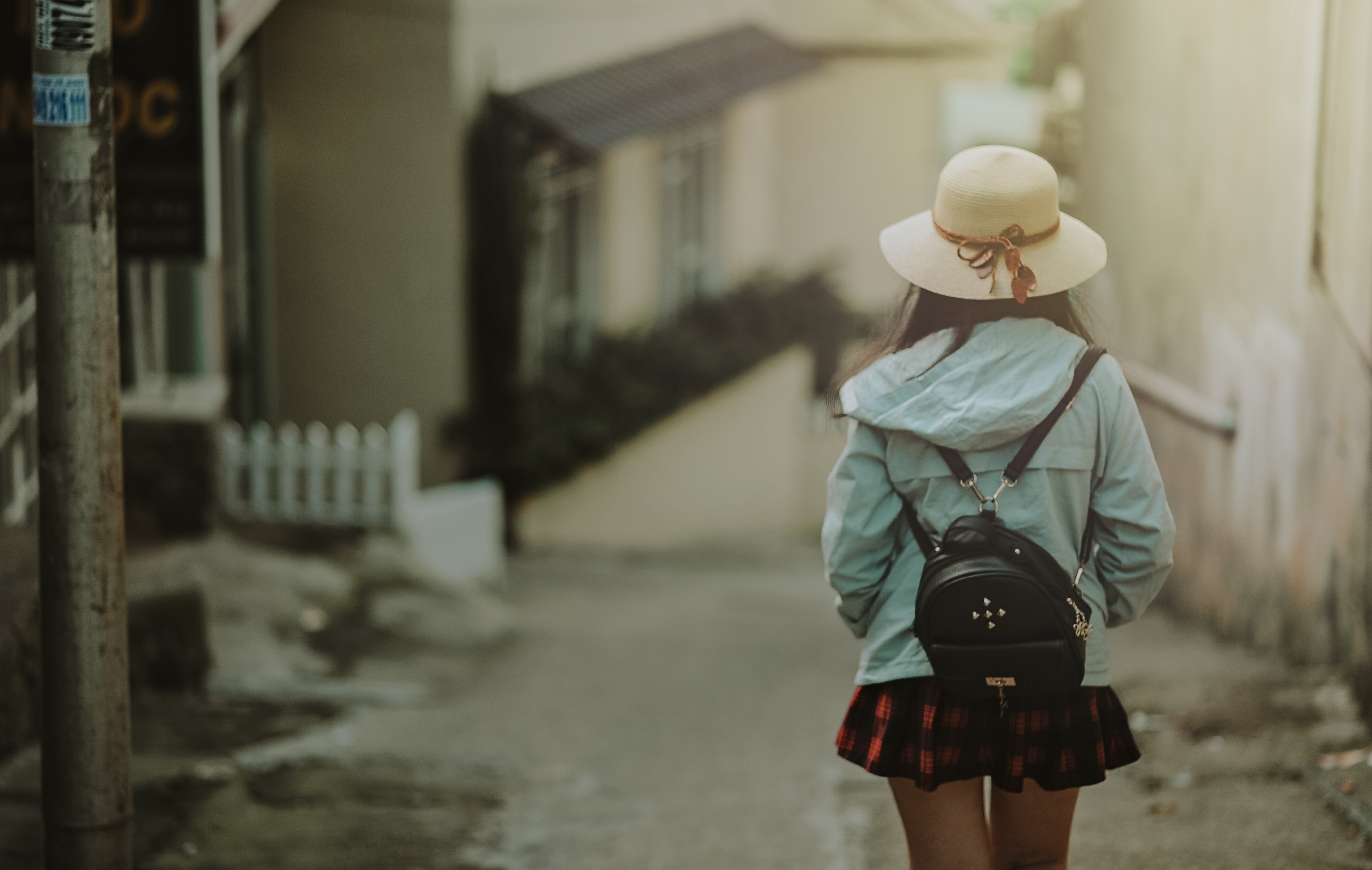 Girl in blue jacket and black leather knapsack walking on street photo