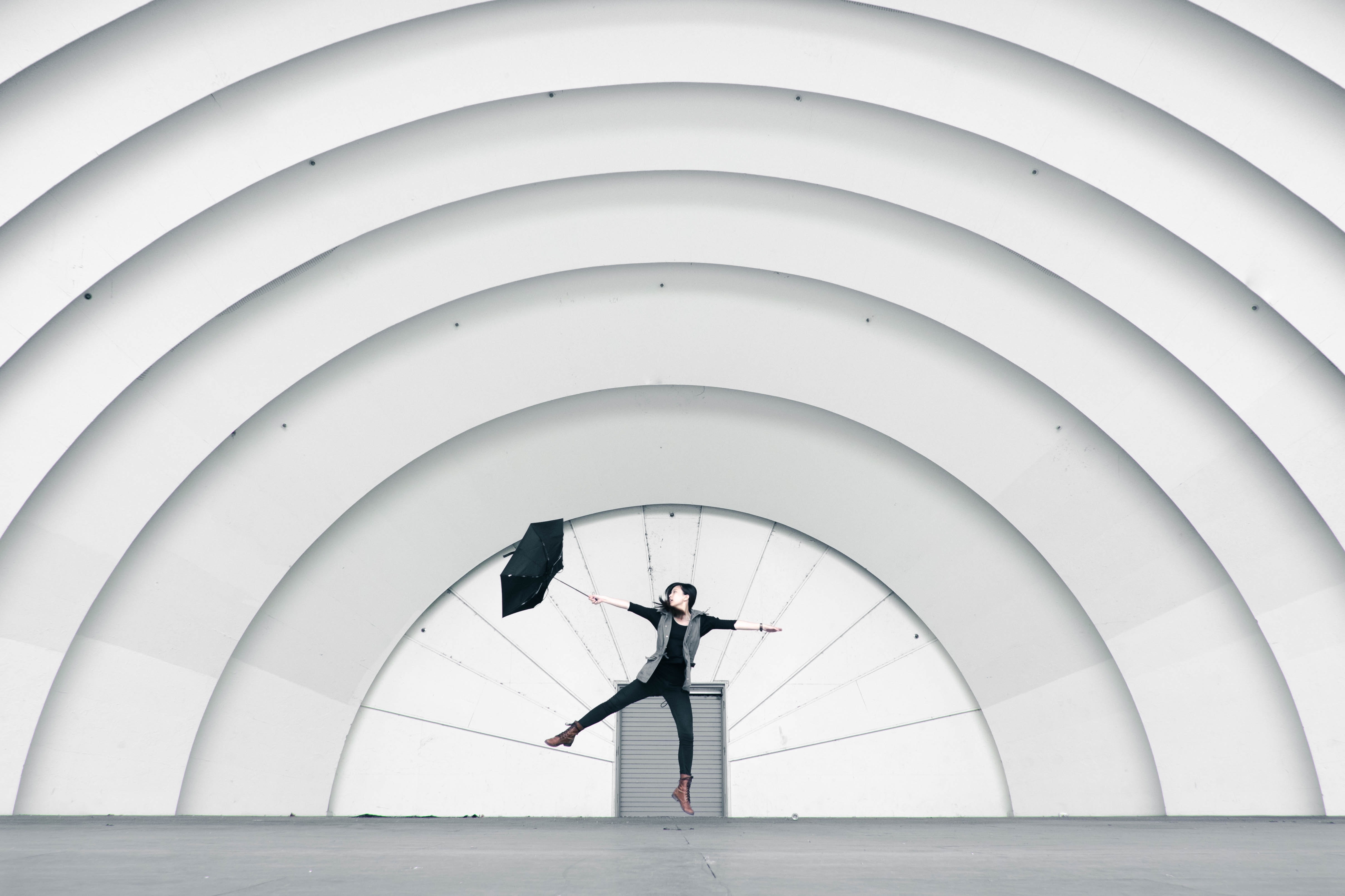 Girl jumping while holding umbrella photo