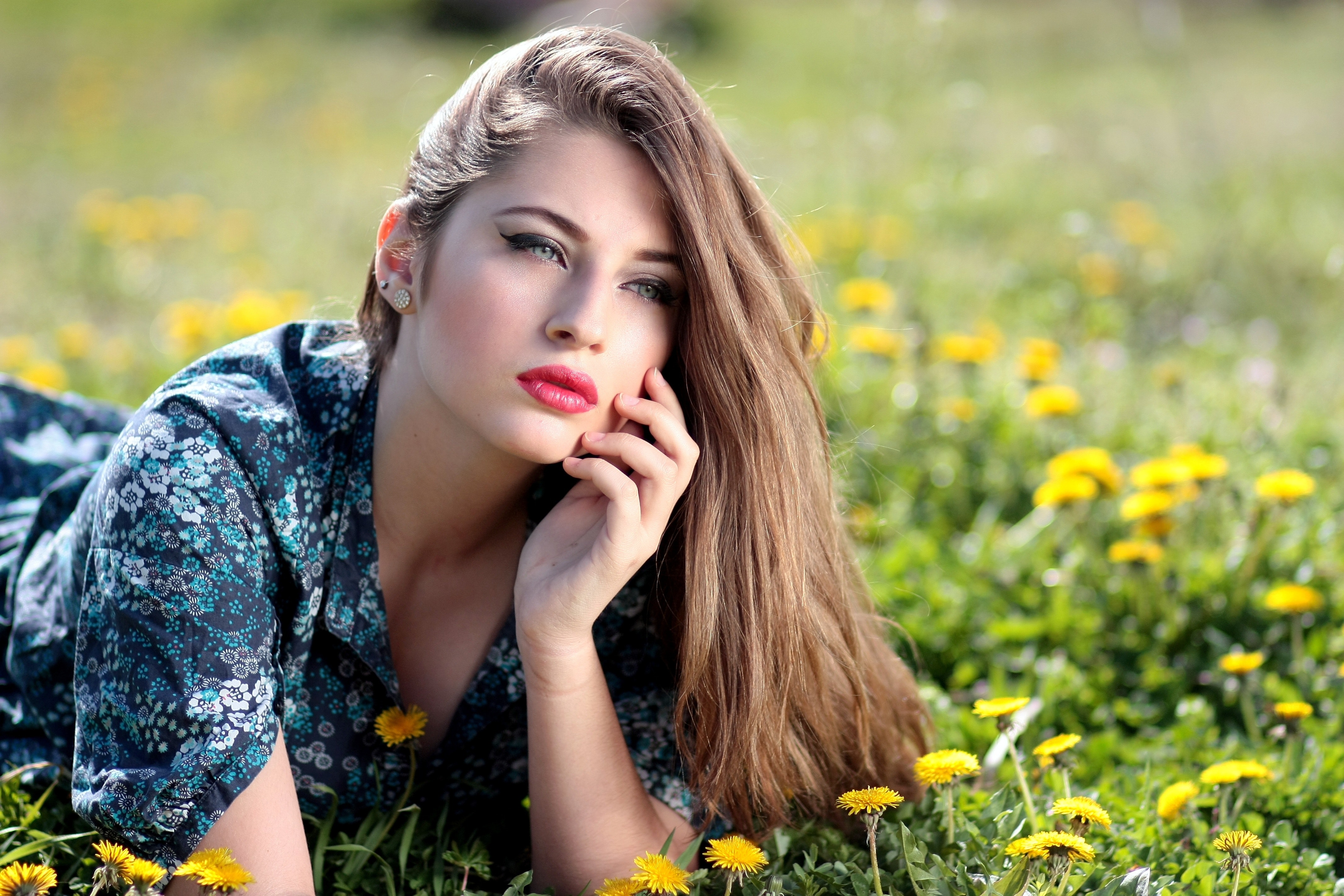 Girl lying on yellow flower field during daytime photo
