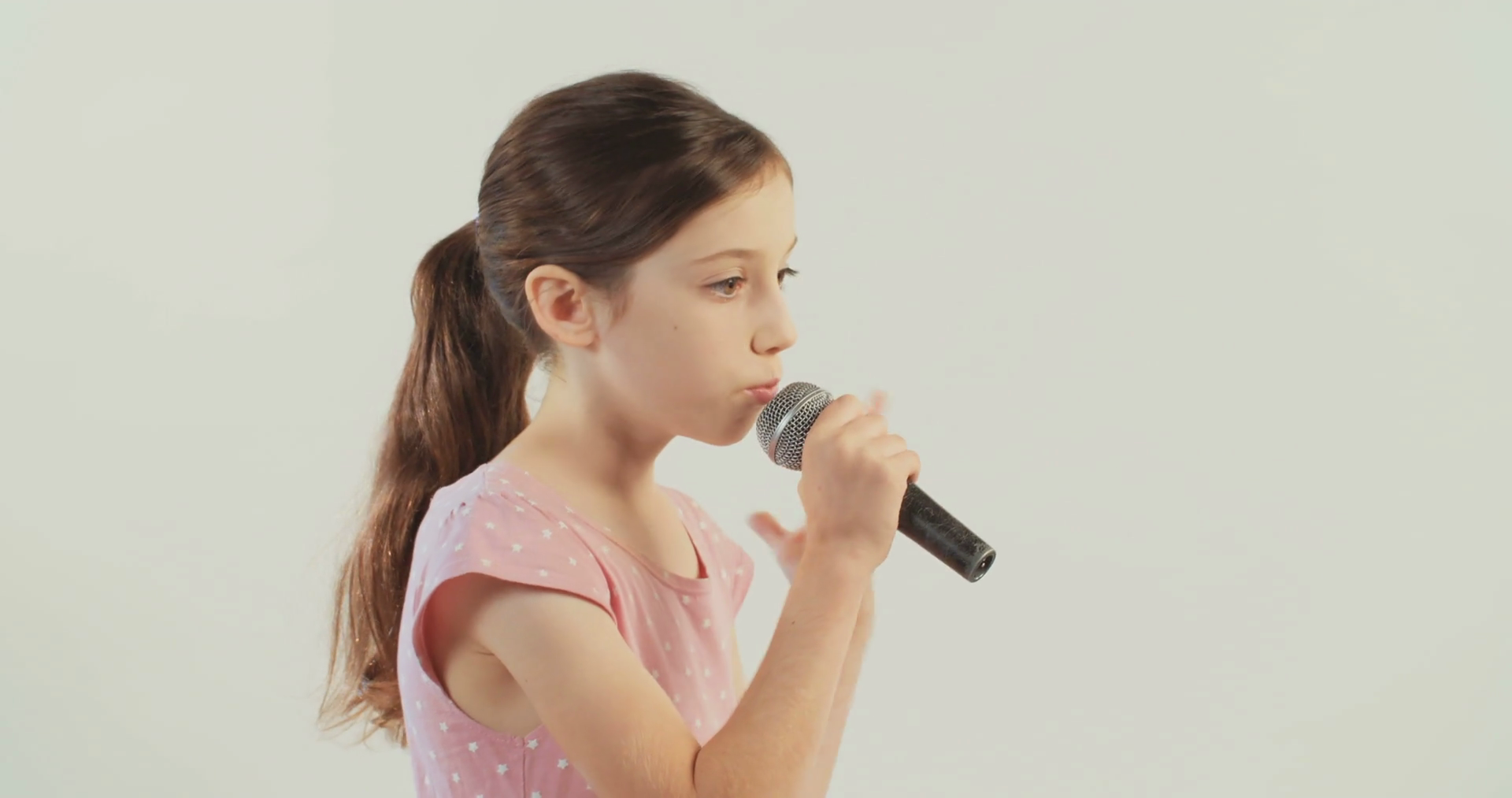 girl singing to a microphone on a white background Stock Video ...