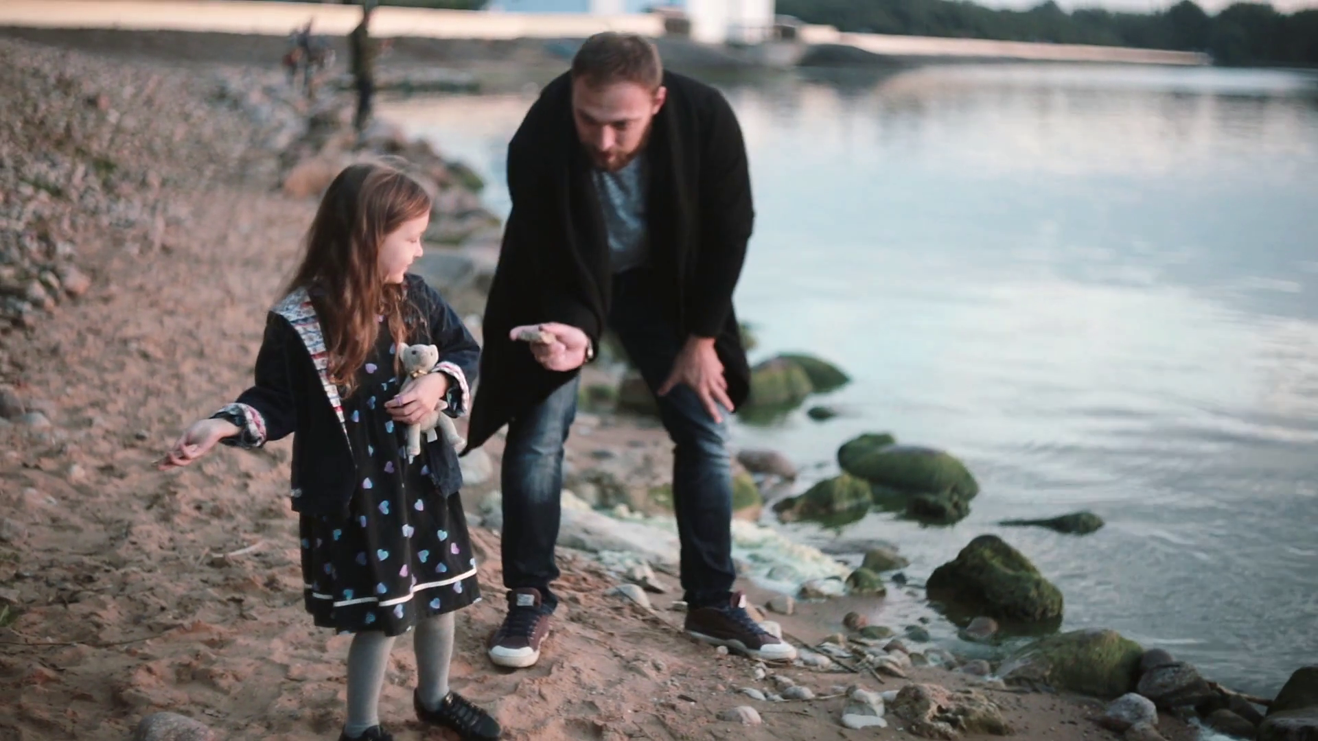 Father and daughter on the shore, little girl throw stone into the ...