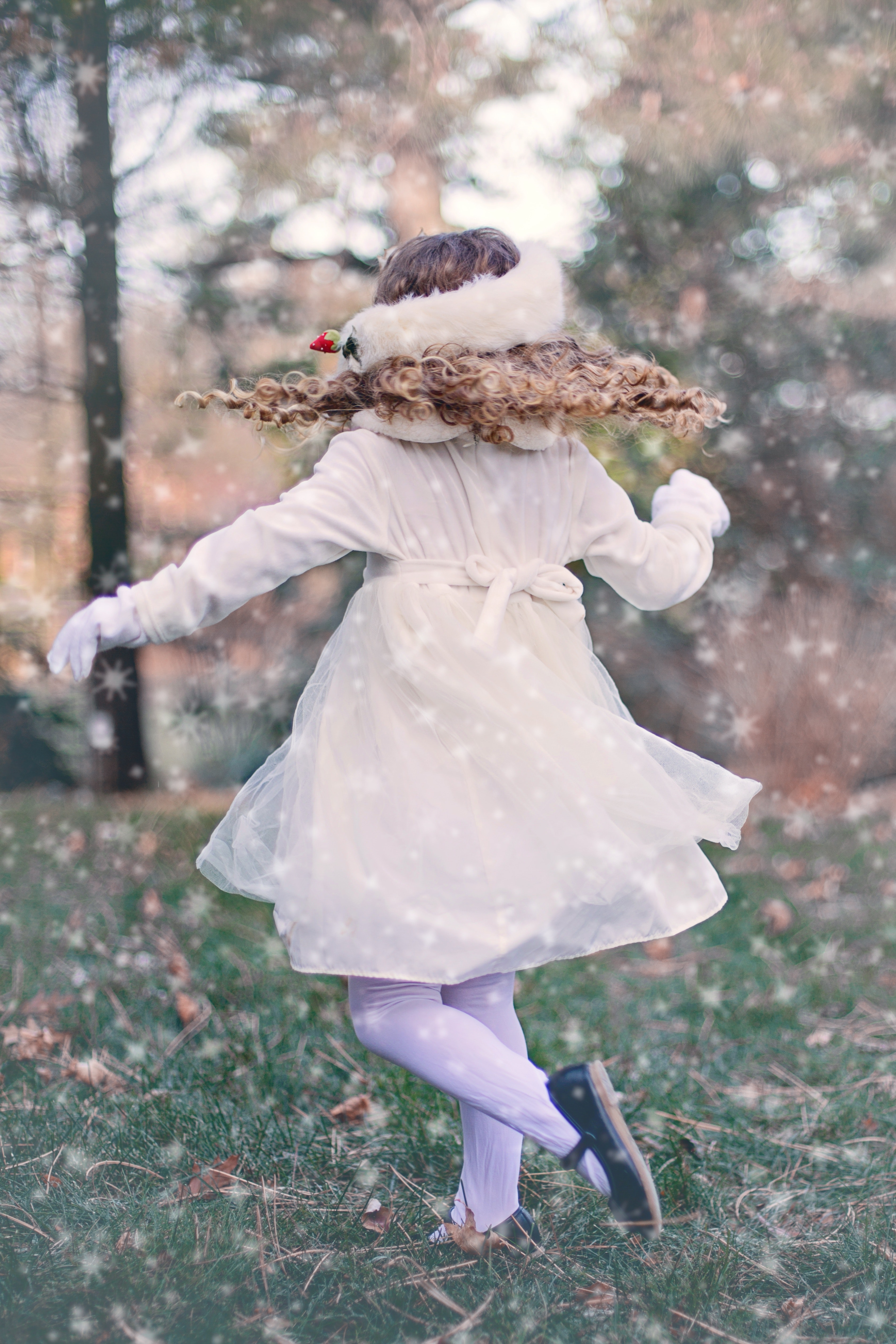 Girl wearing white long sleeve dress standing on green grass field photo