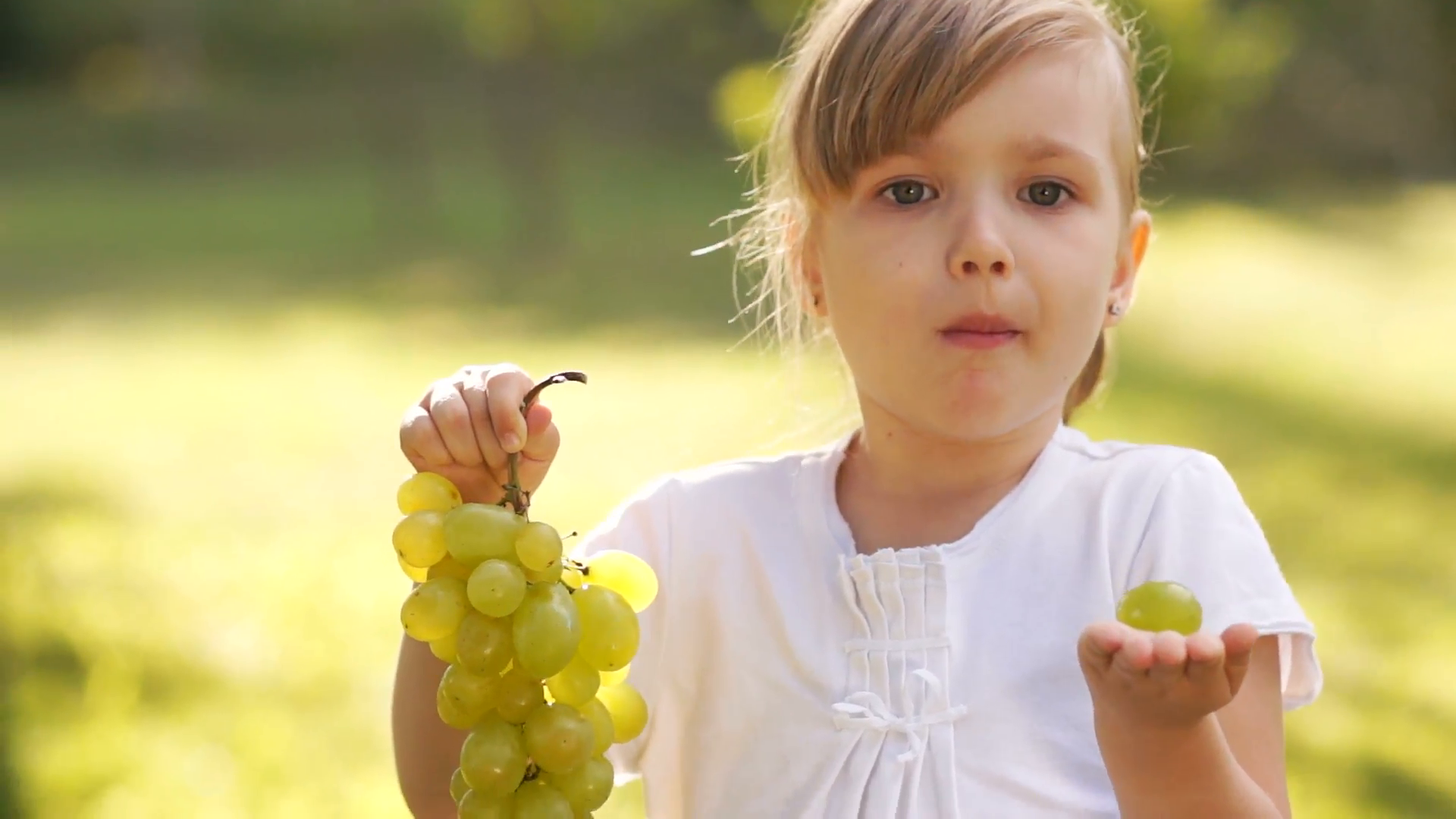 Little girl holding grapes Stock Video Footage - Videoblocks