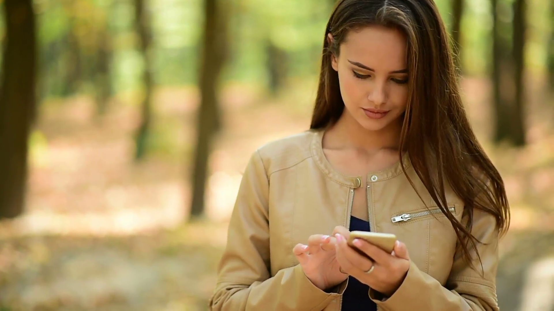 Beautiful young woman reads message on the mobile phone. Girl with ...