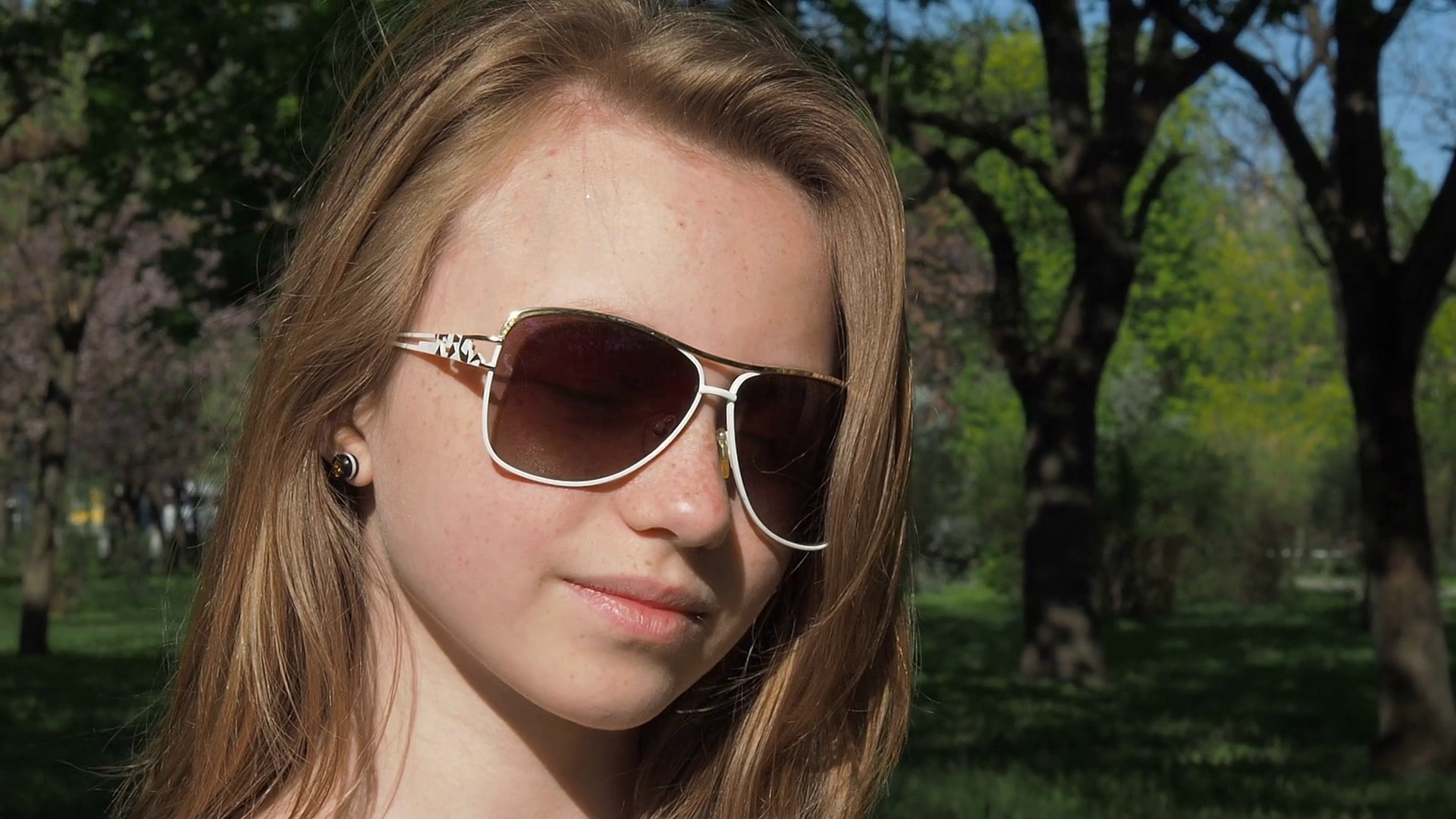 Girl in sunglasses close-up. A teenage girl with freckles takes off ...