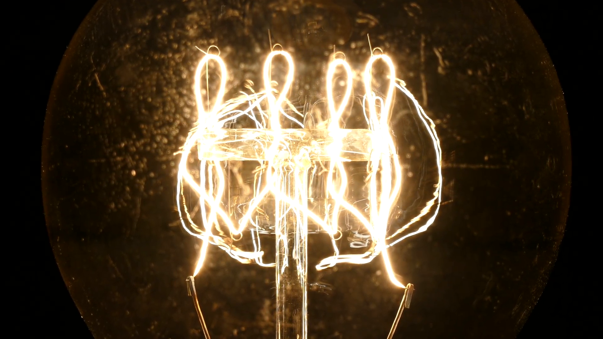 Zooming macro of glowing vintage incandescent light bulb filament ...