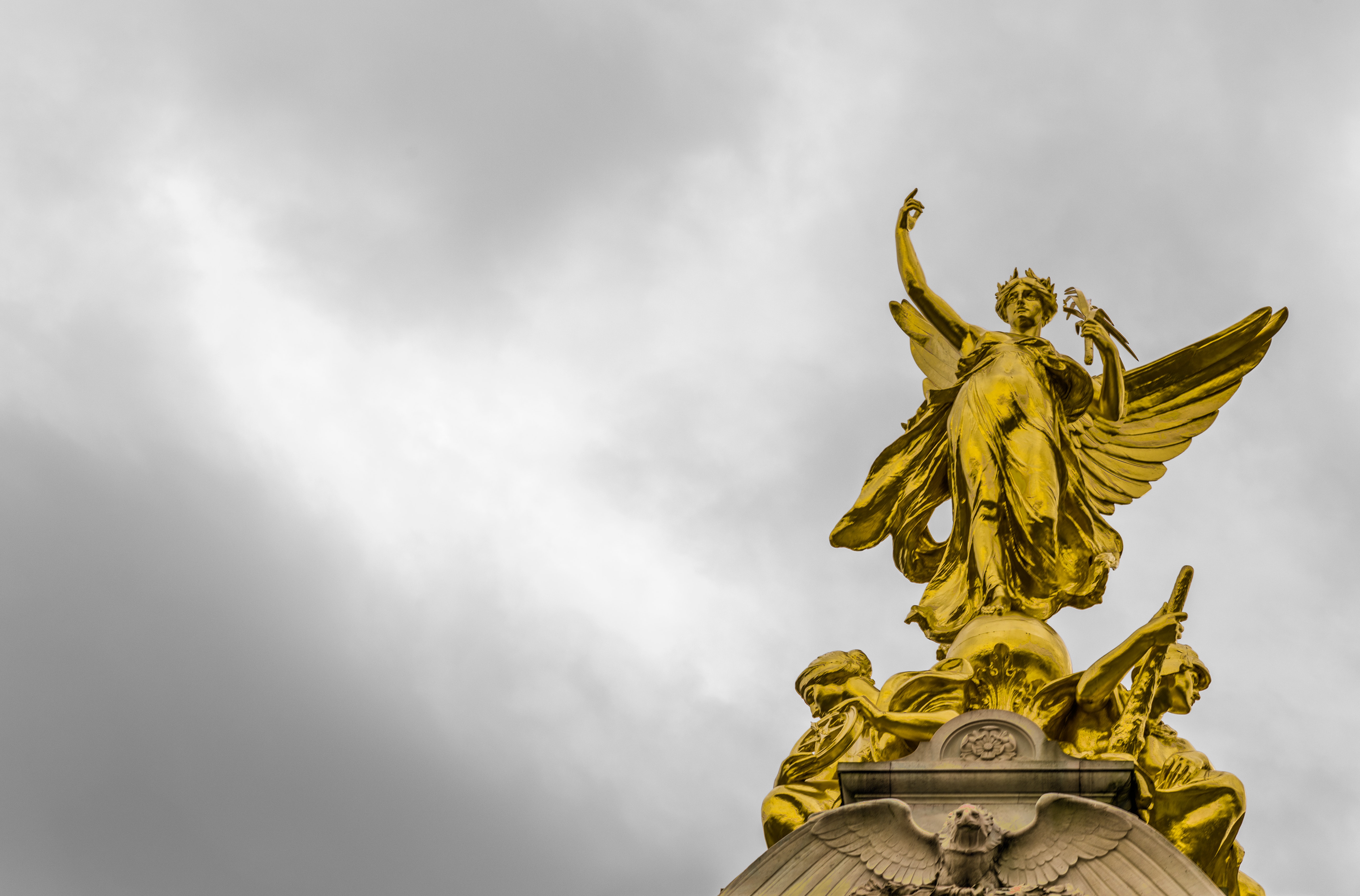 Gold angel statue under grey clouds photo