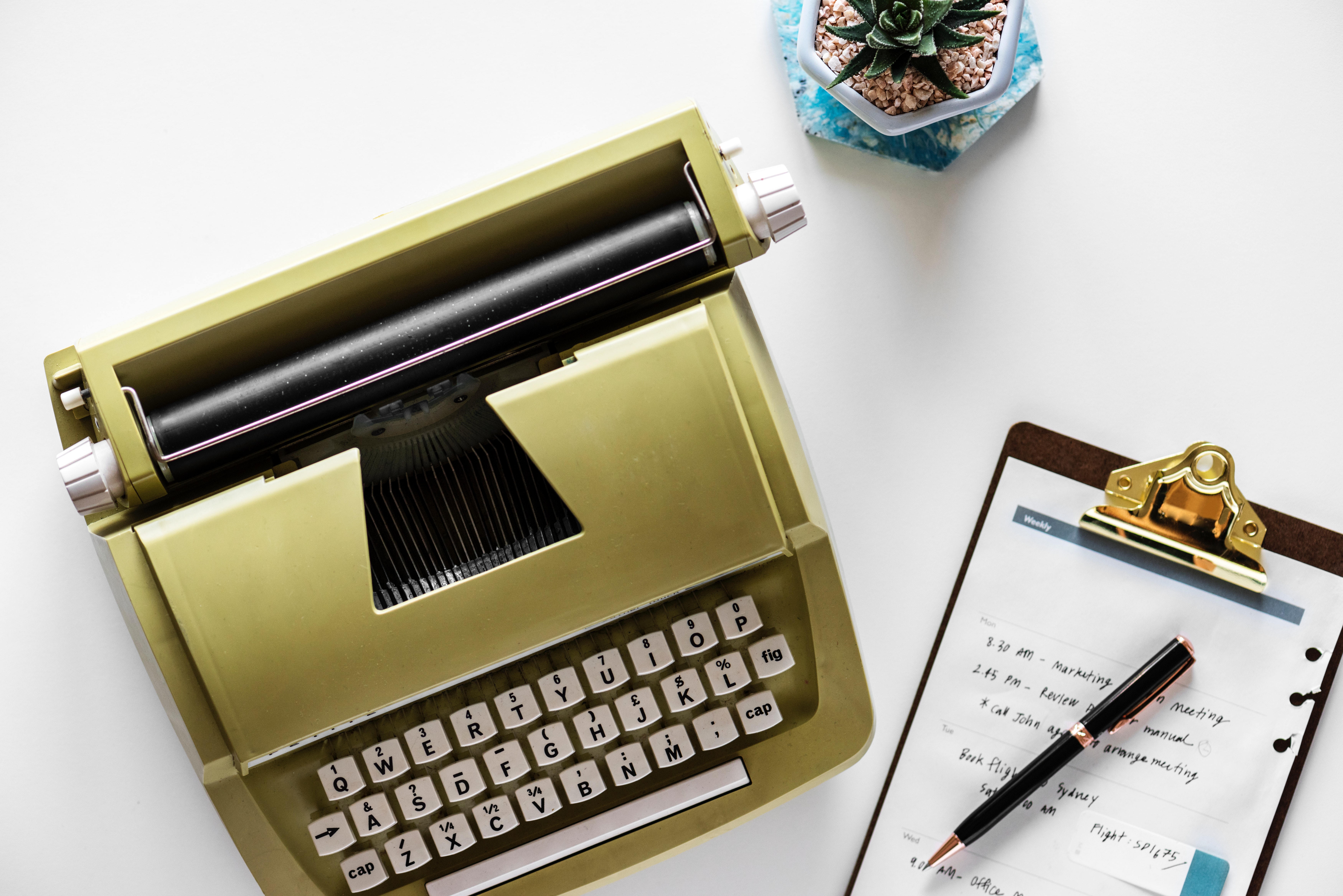 Gold type writer beside clip board and click pen photo