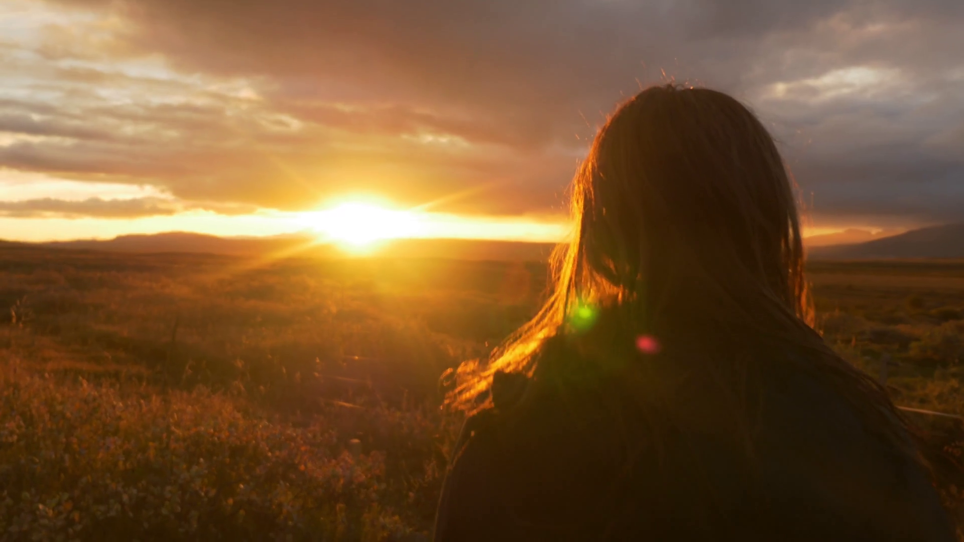 Iceland sunset at golden hour - girl looking into field Stock Video ...