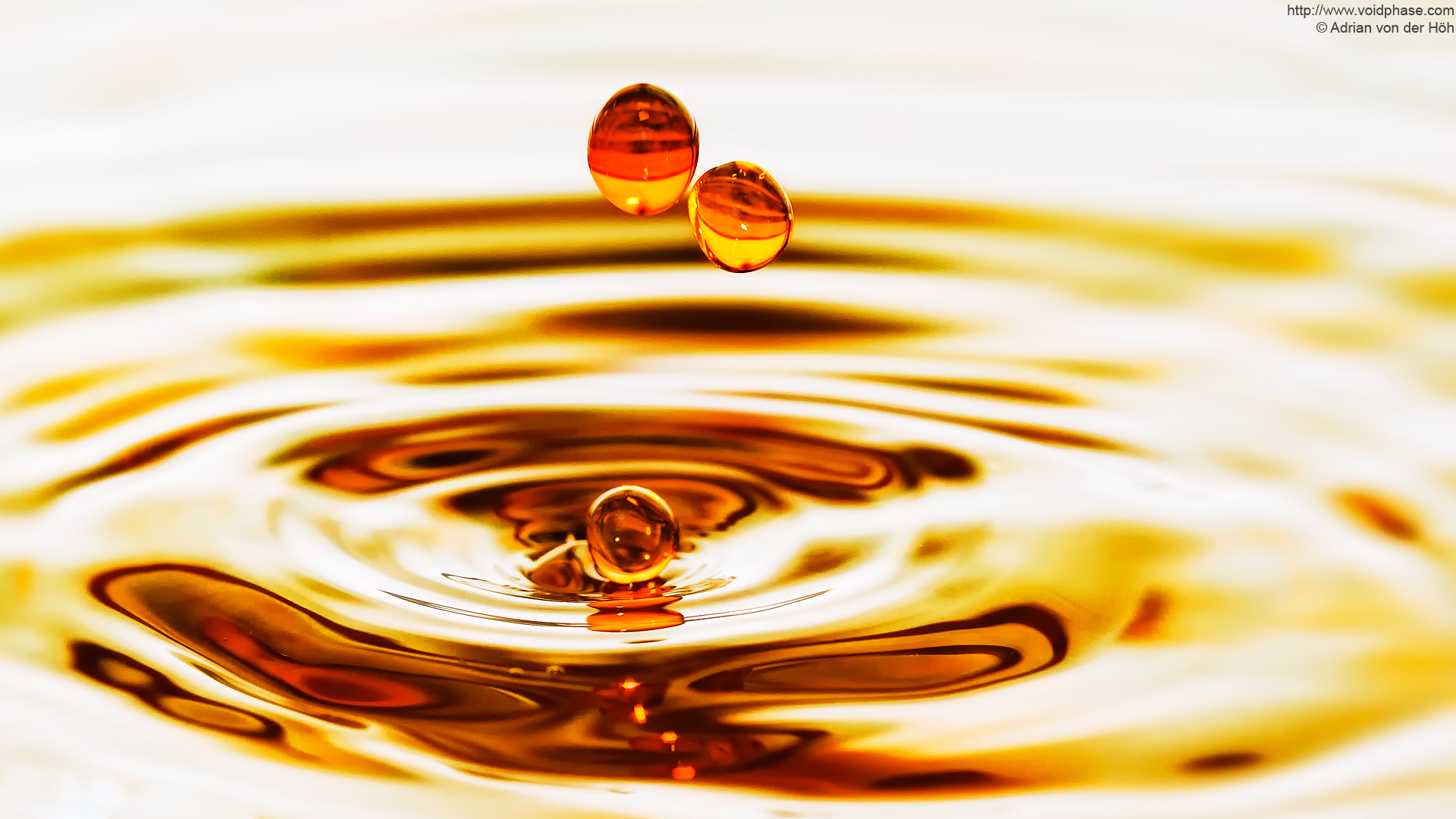 Photo of golden drops of water over a liquid surface | Voidphase ...