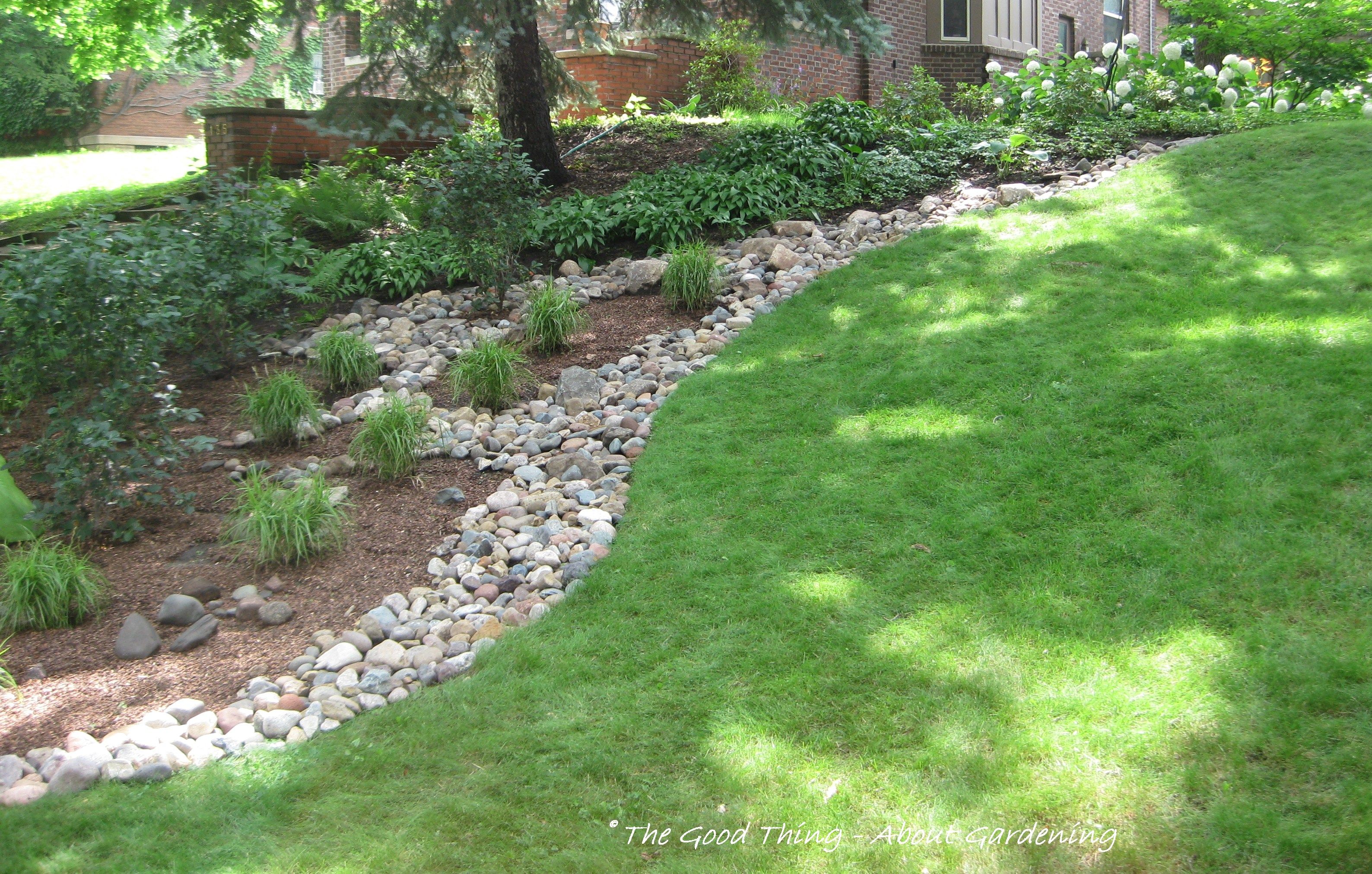 river rock as a divider between the grass and plant beds | yard ...