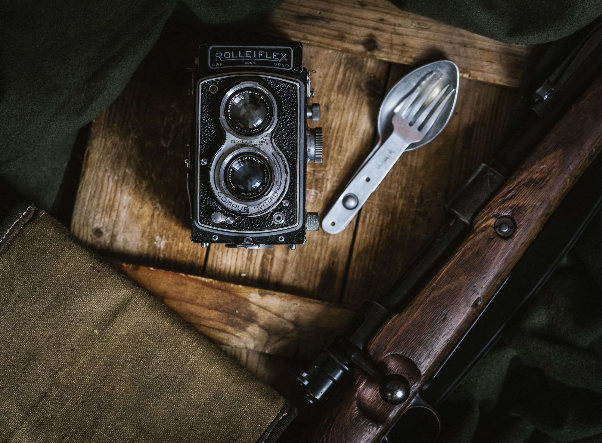 Gray and black rolleiflex camera beside fork and spoon decor photo