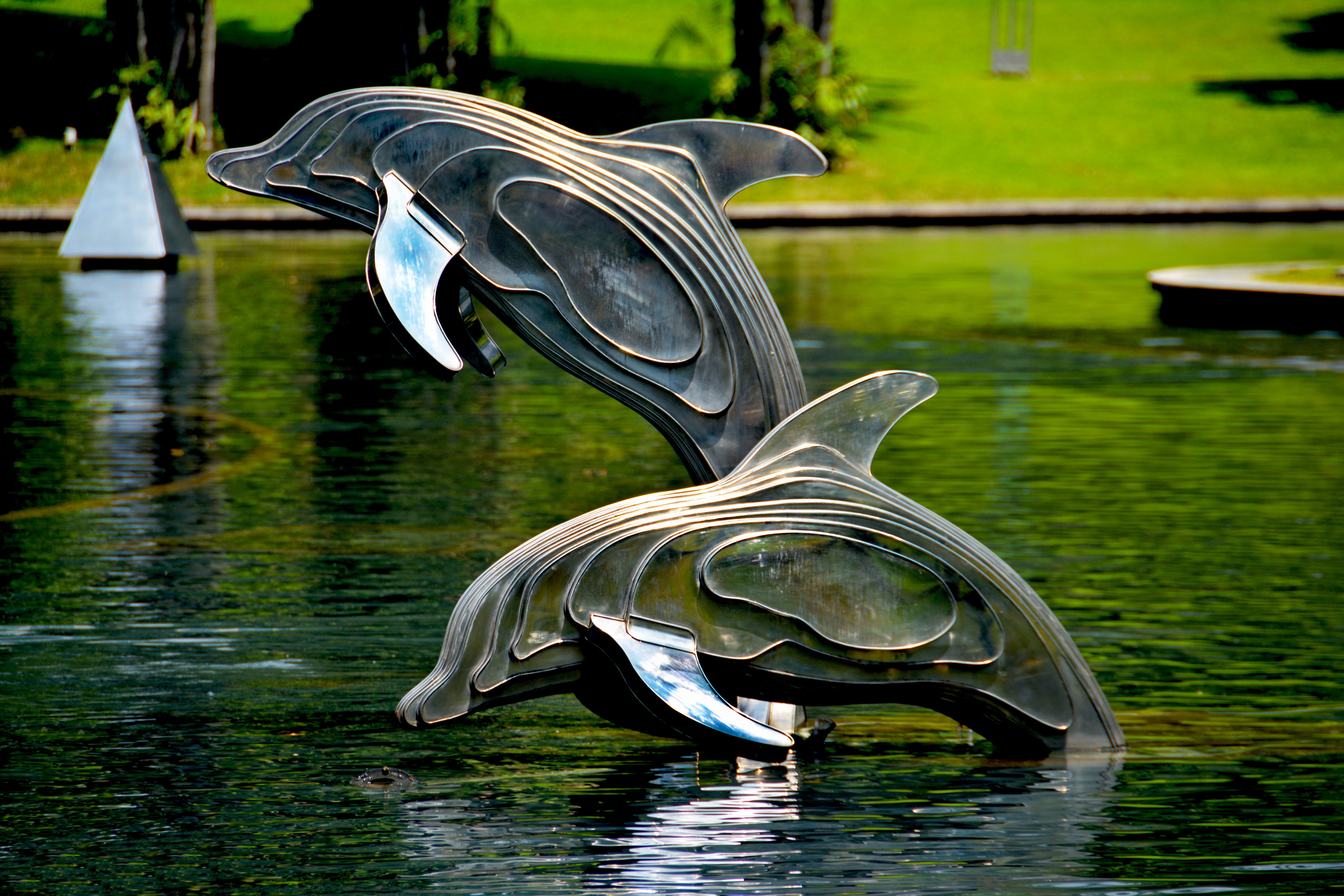 Gray and brass metal dolphin pool decor photo