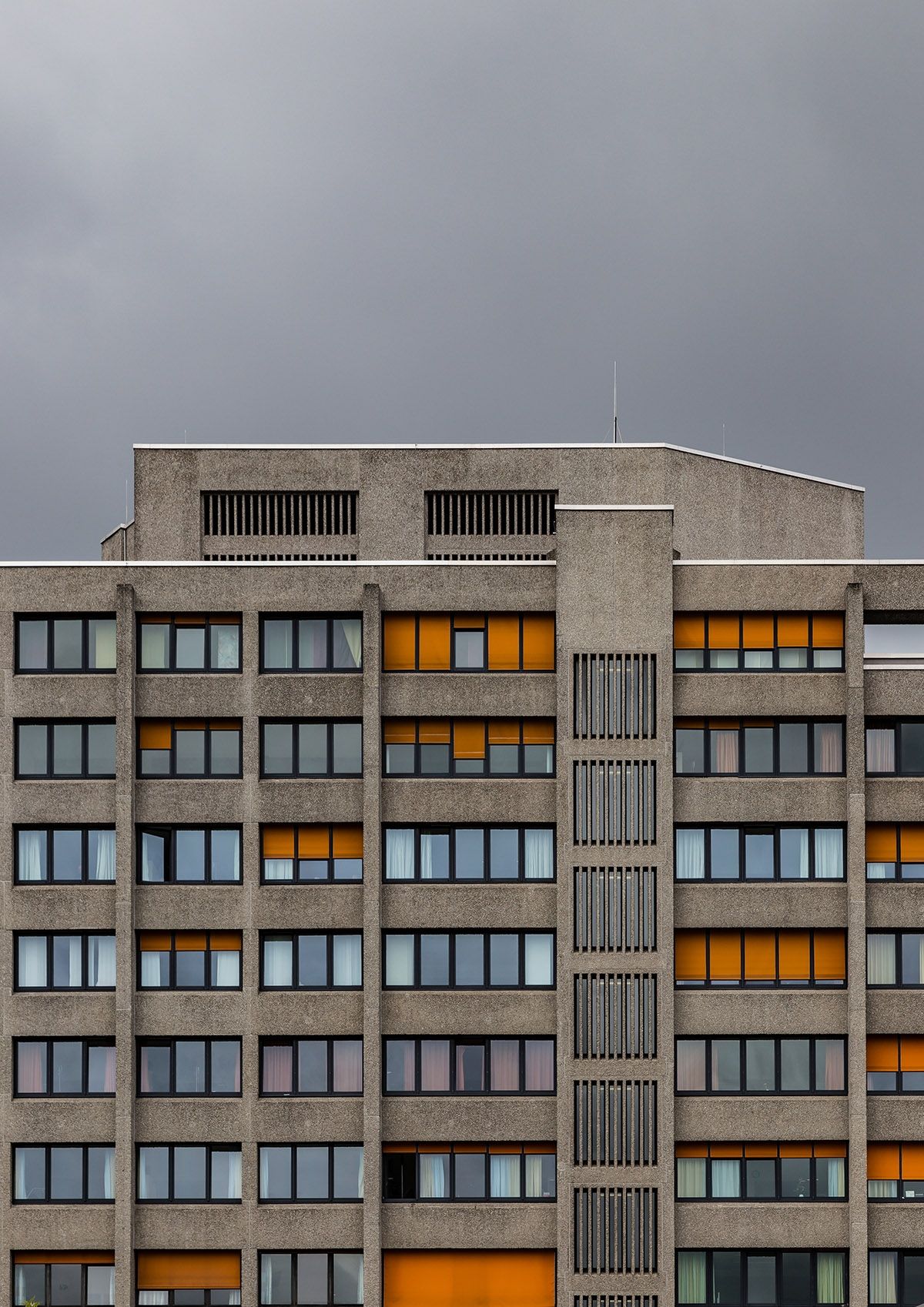 Grey, concrete buildings set against a dark, stormy sky would make ...
