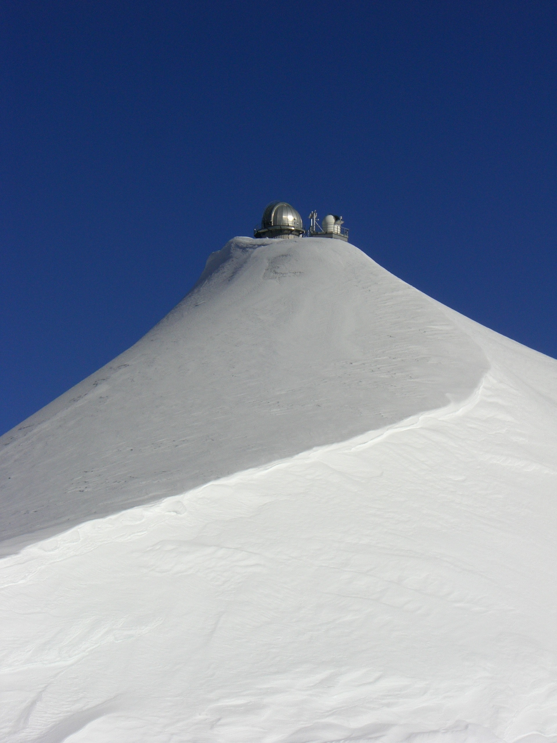 Gray round weather device on top of snow coated mountain during daytime photo