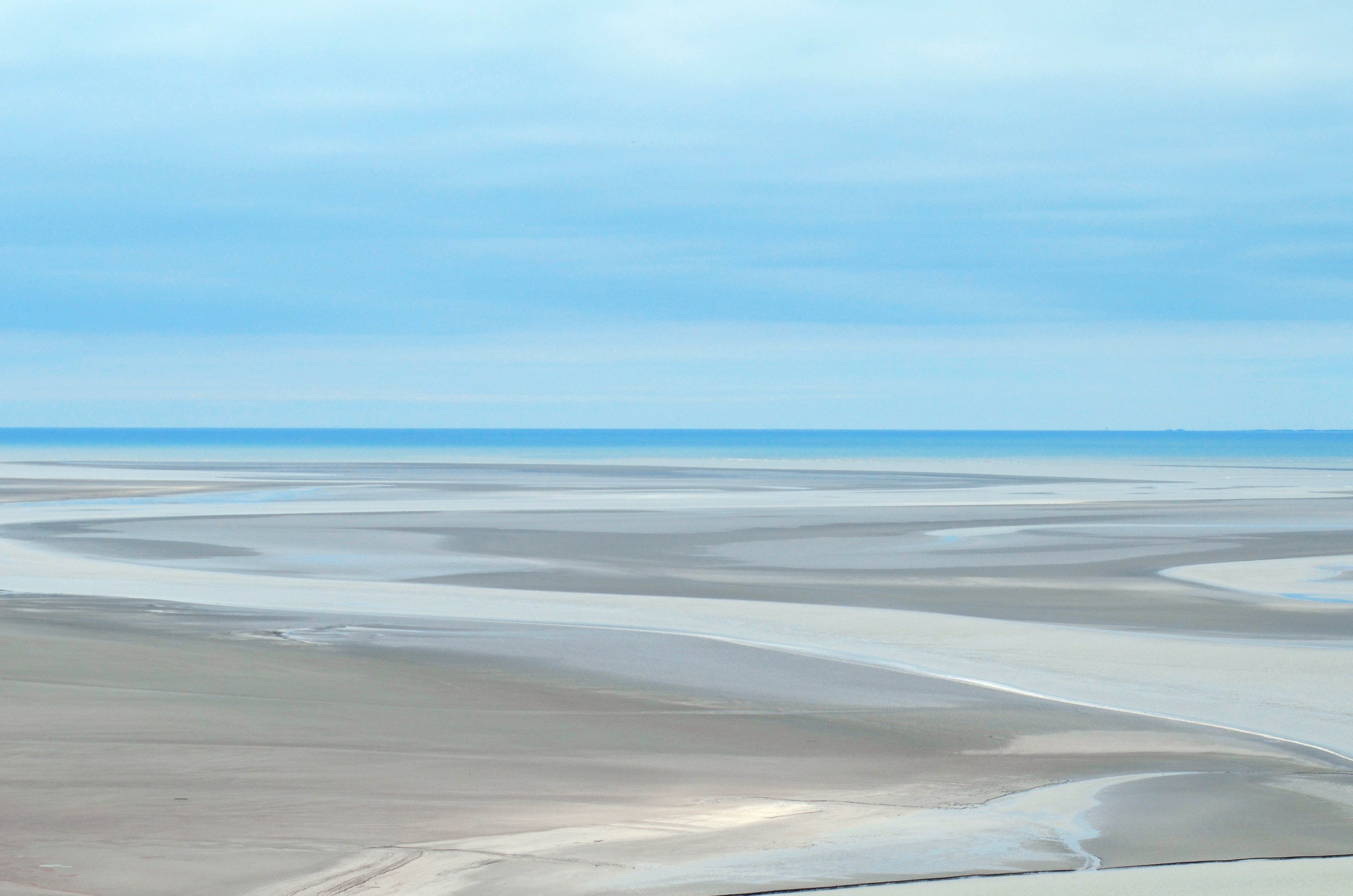 Gray sand dunes under blue sky photo
