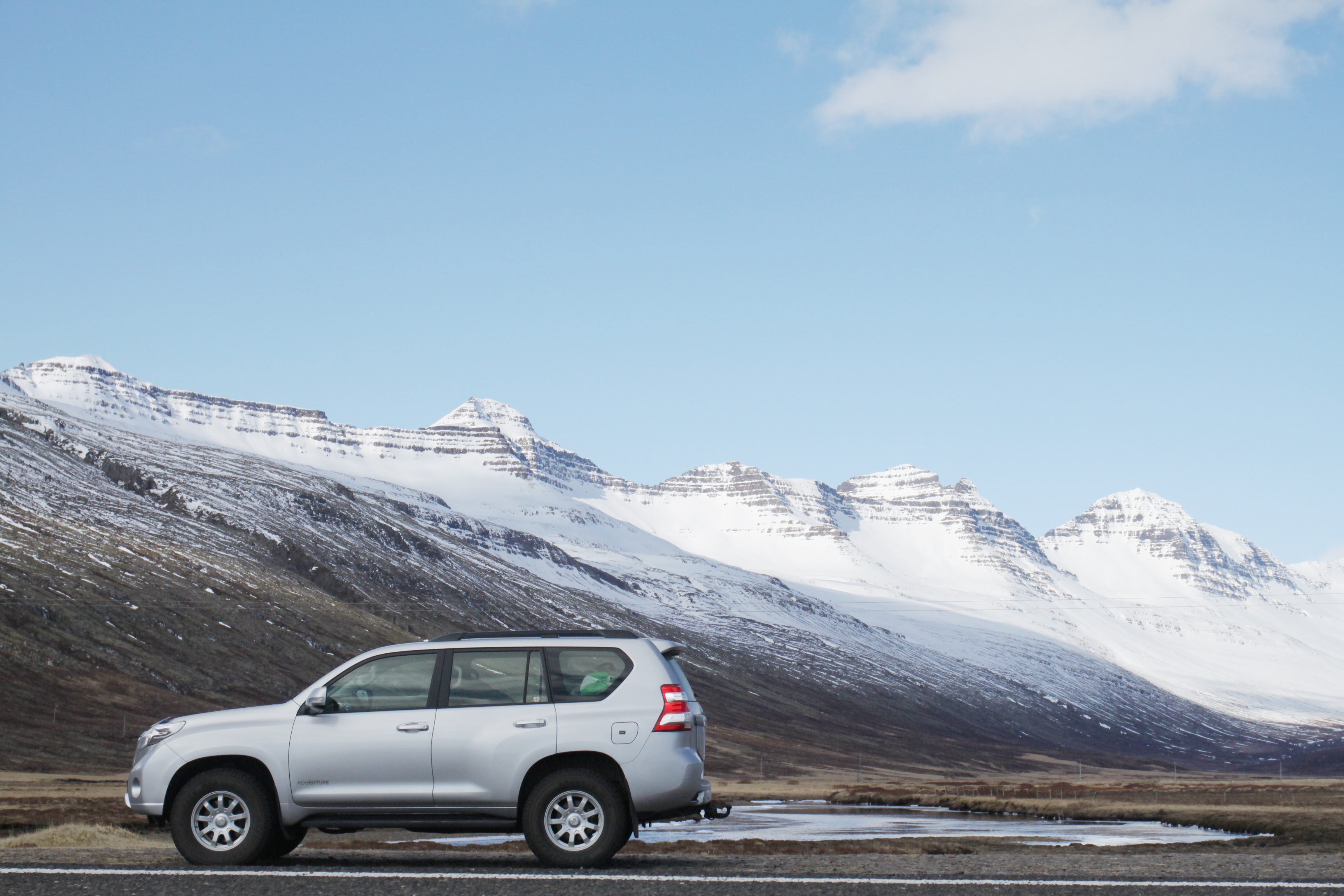 Gray sports utility vehicle on road near snow covered mountain photo