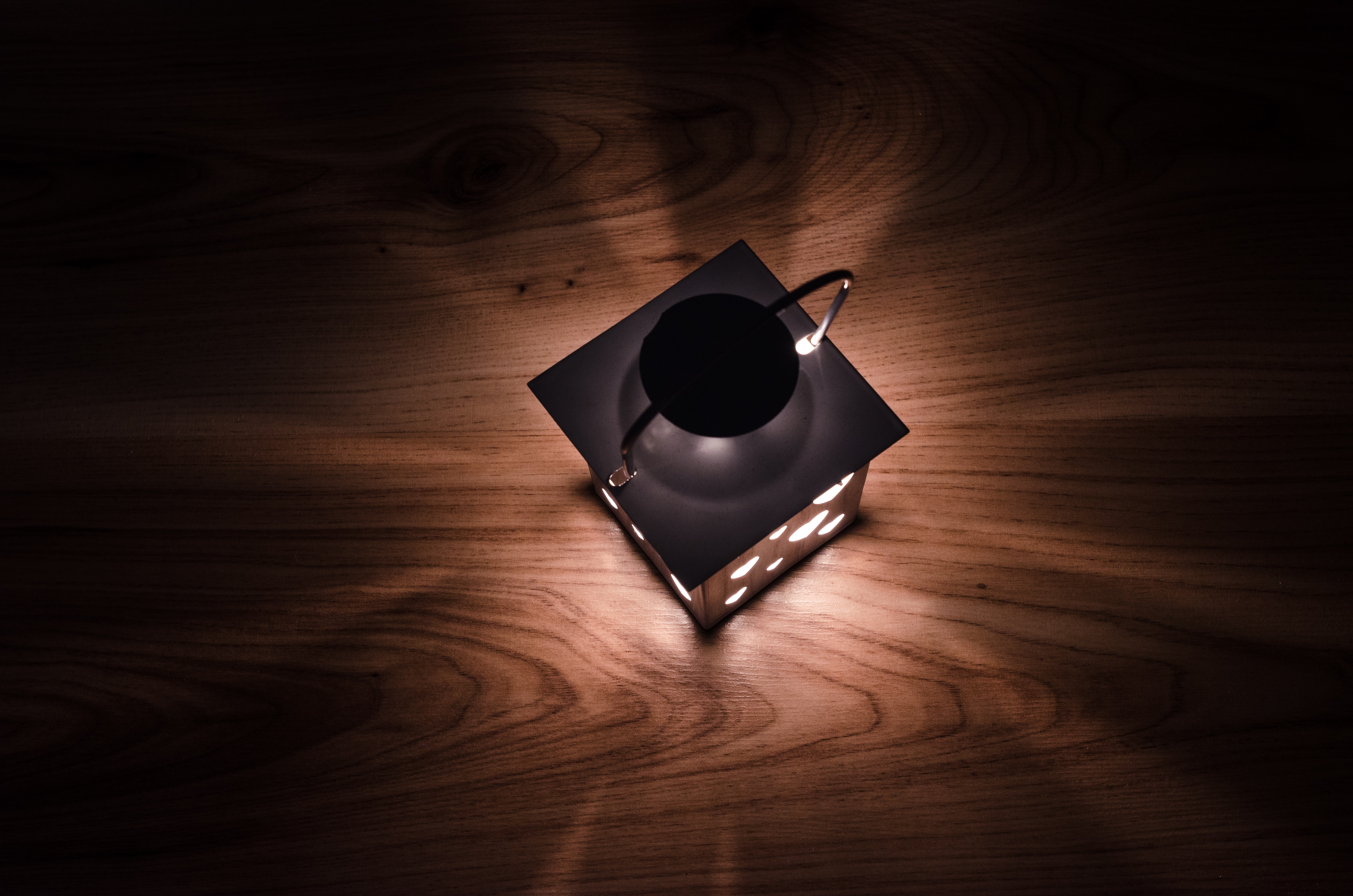 Gray steel candle lantern on brown wooden board photo