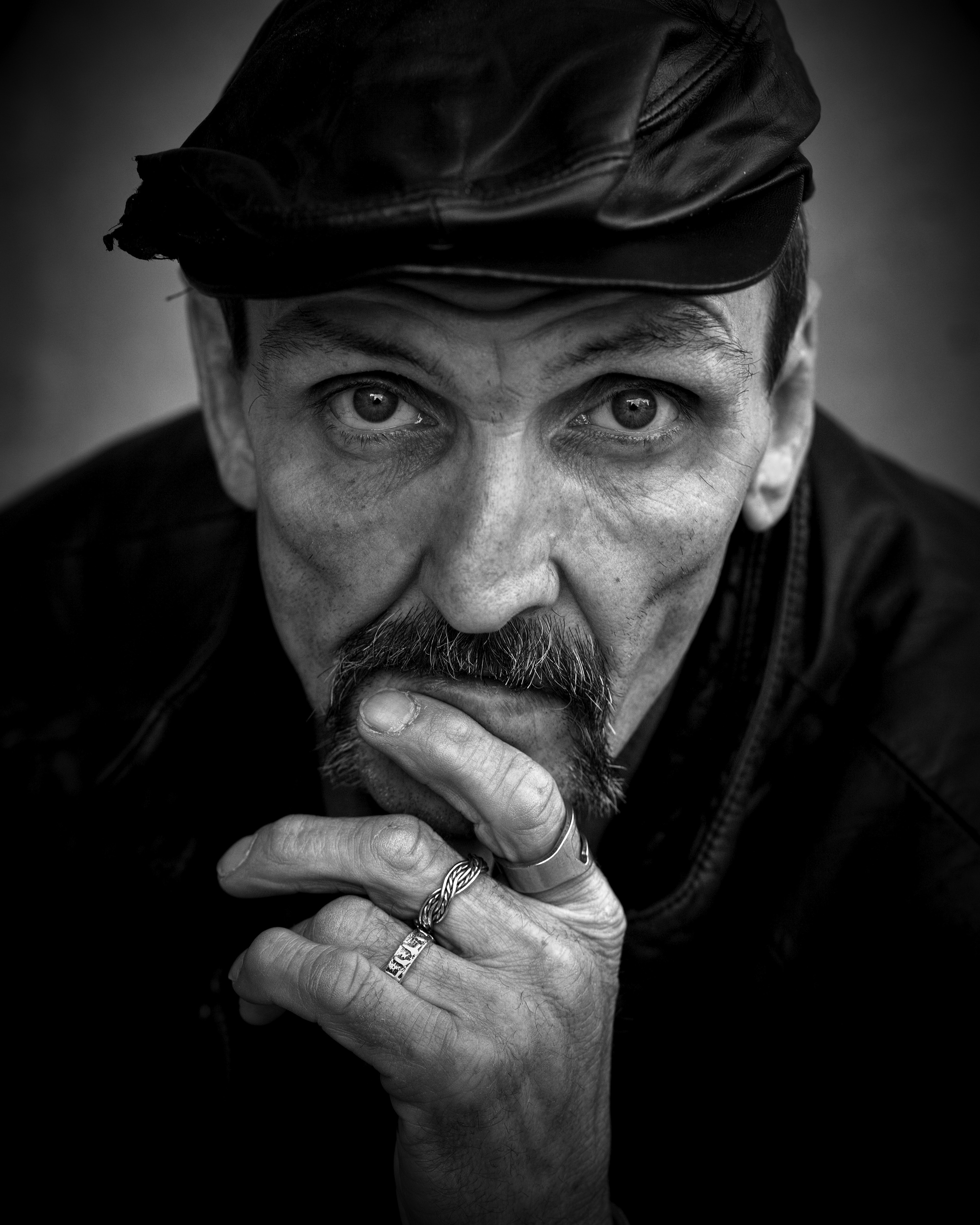 Grayscale of photo of men's wearing black leather hat
