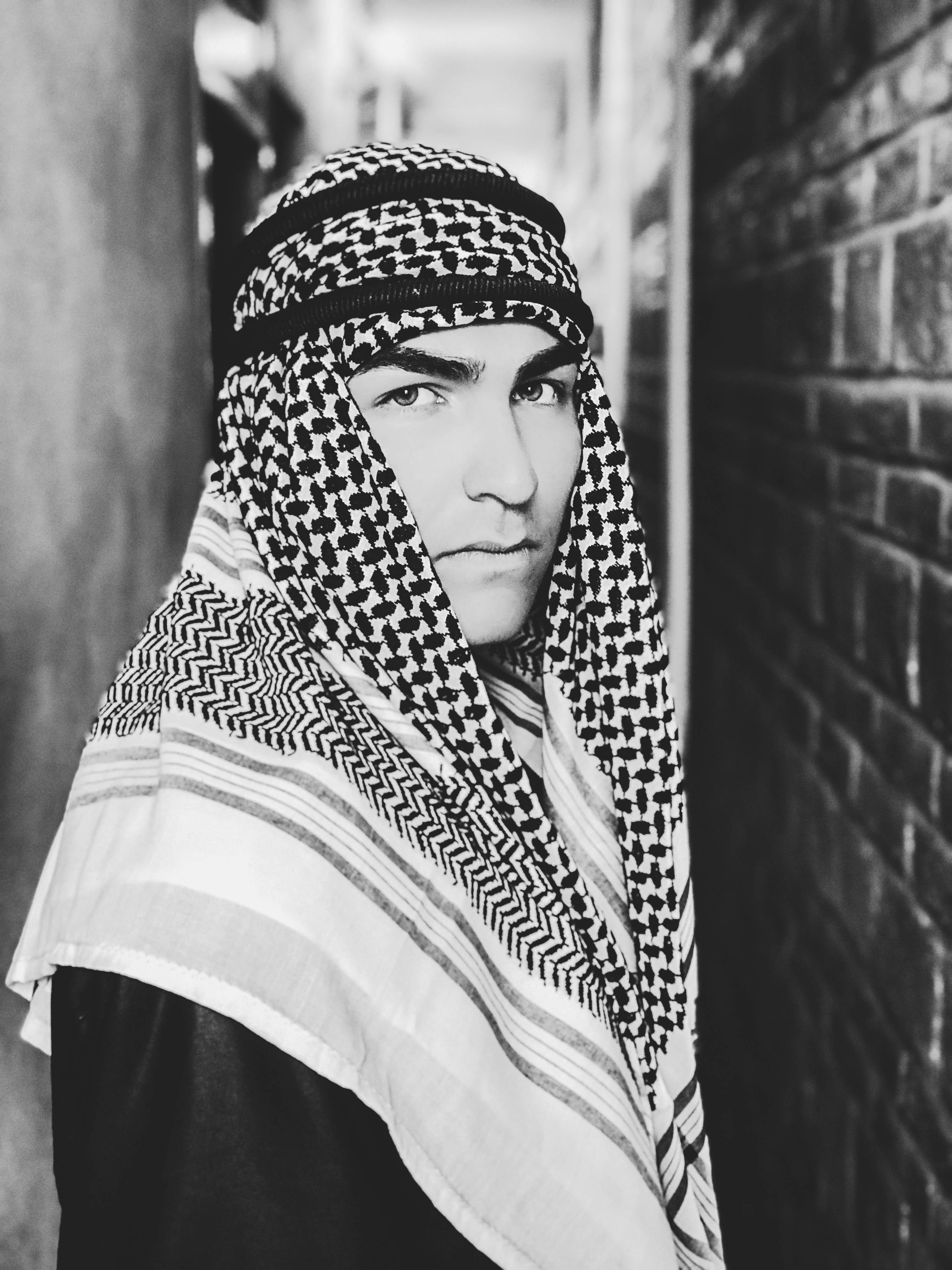 Grayscale photo of a man wearing keffiyeh