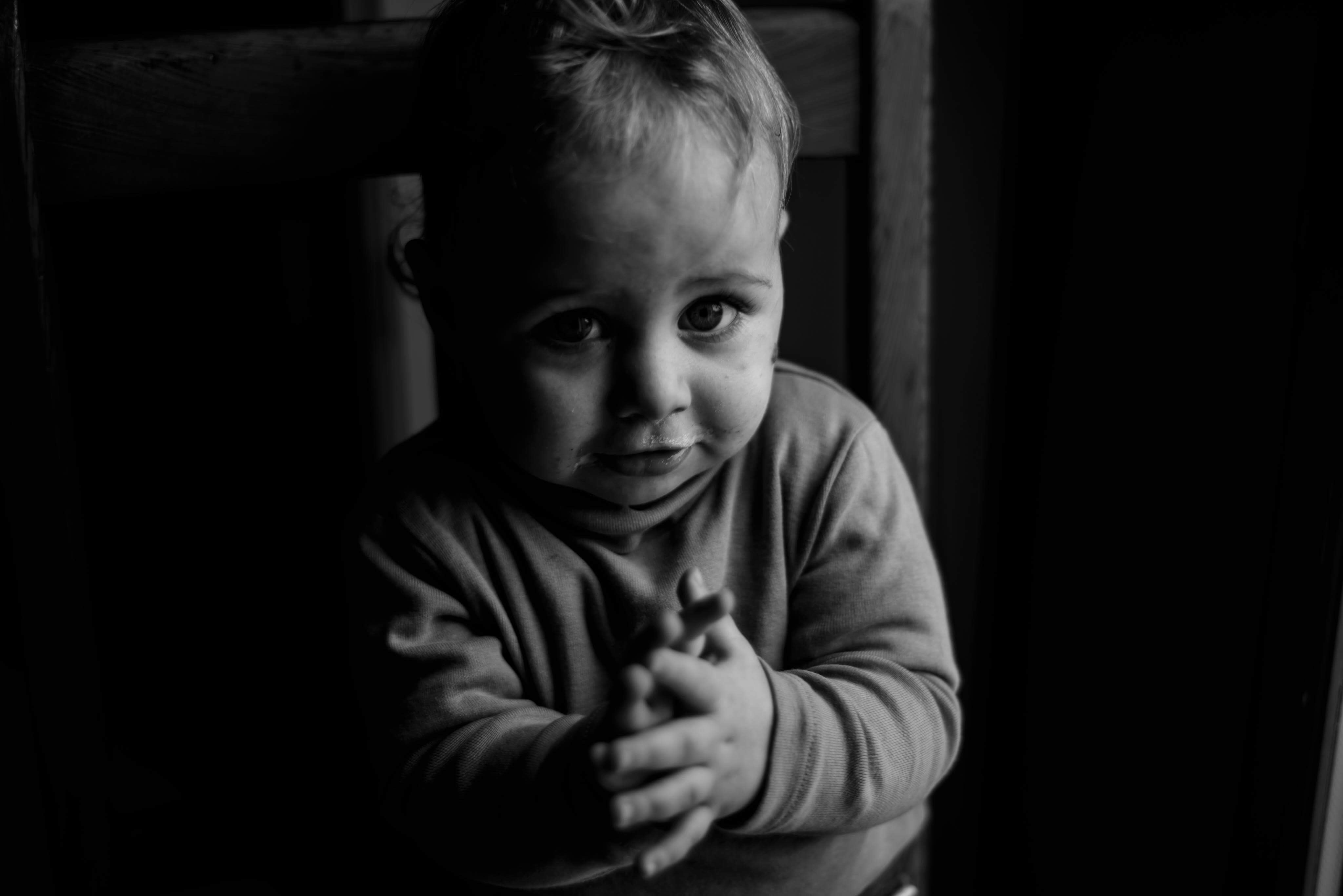 Grayscale photo of baby sitting on chair