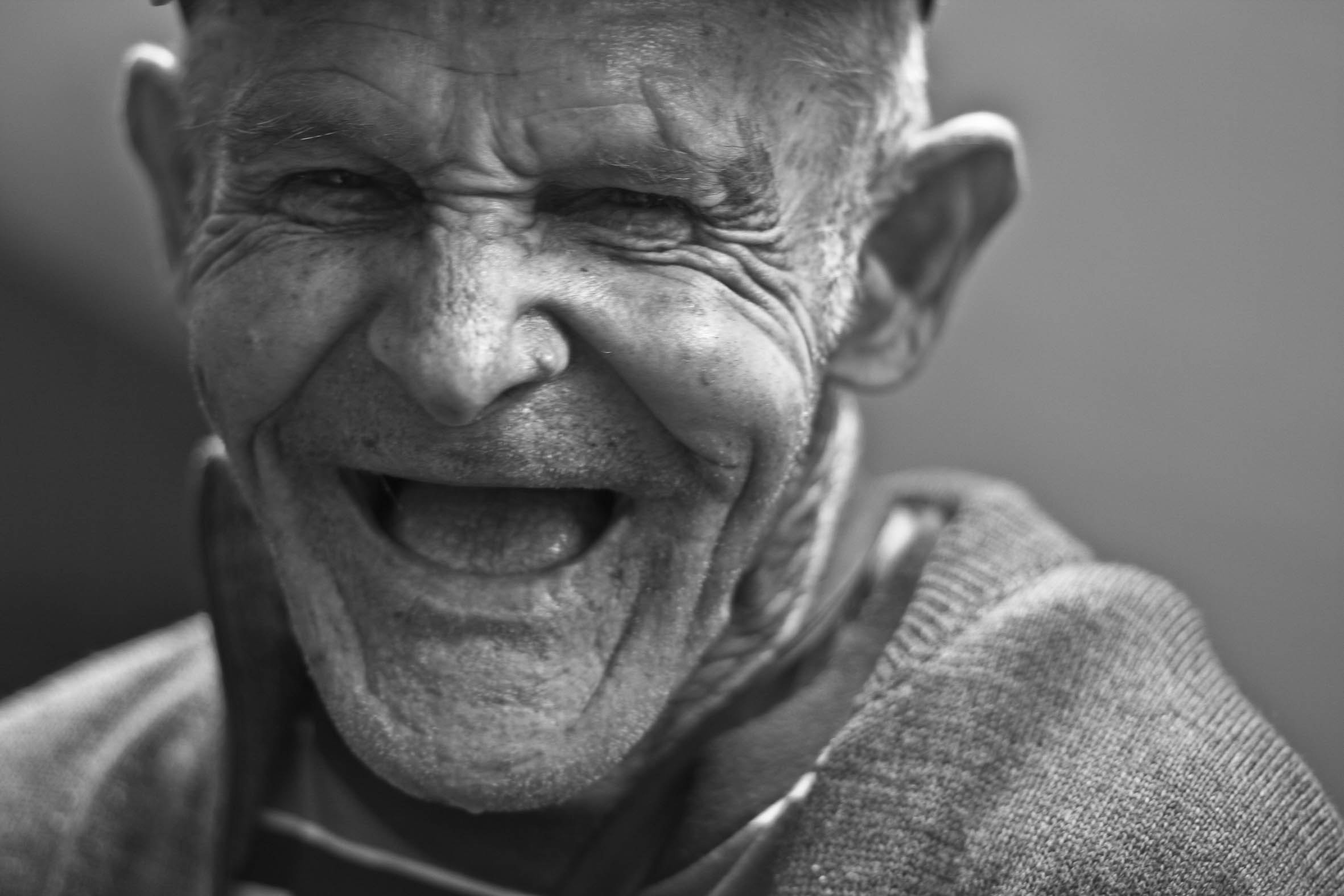 Grayscale photo of laughing old man
