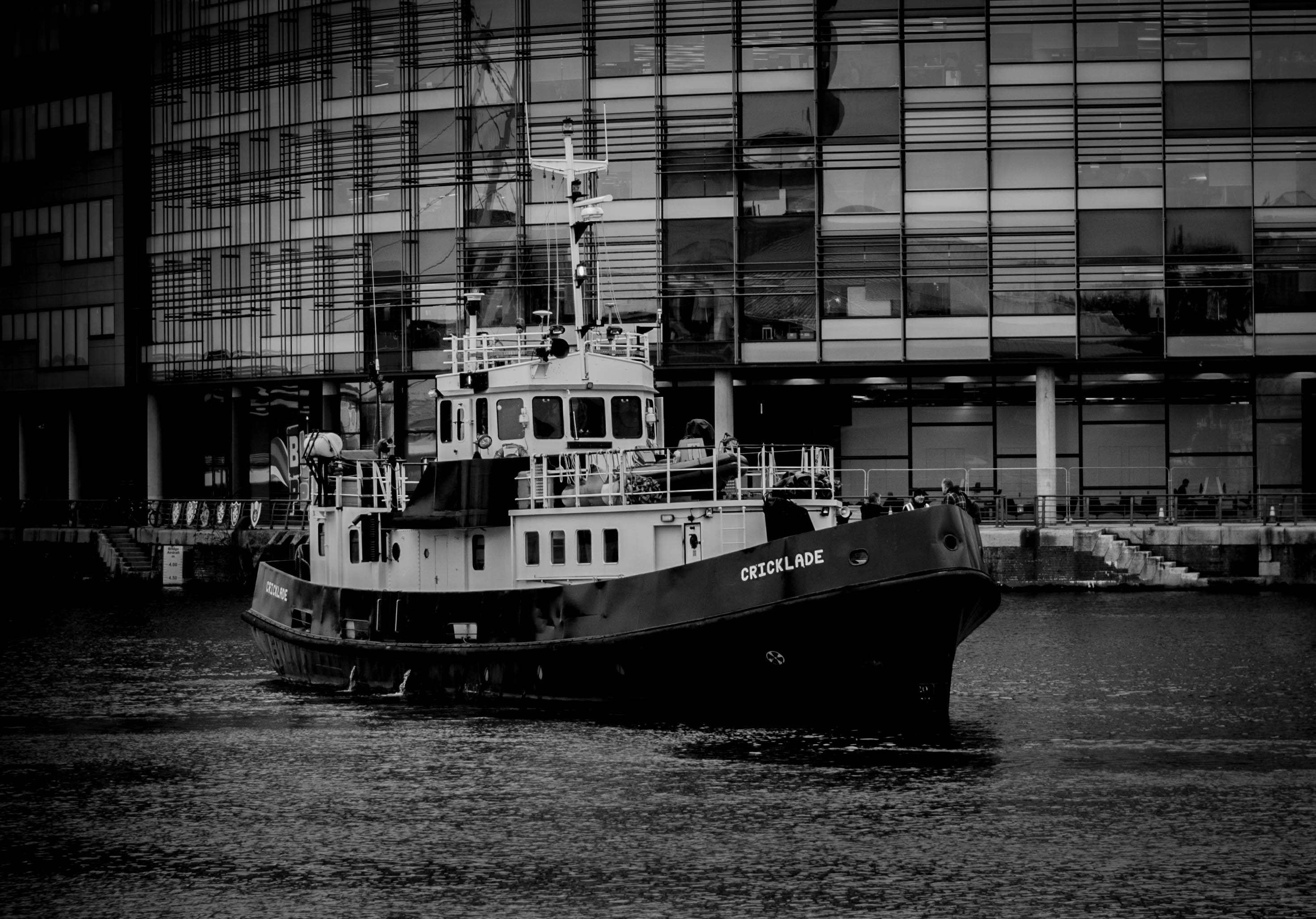 Grayscale photo of ship near building