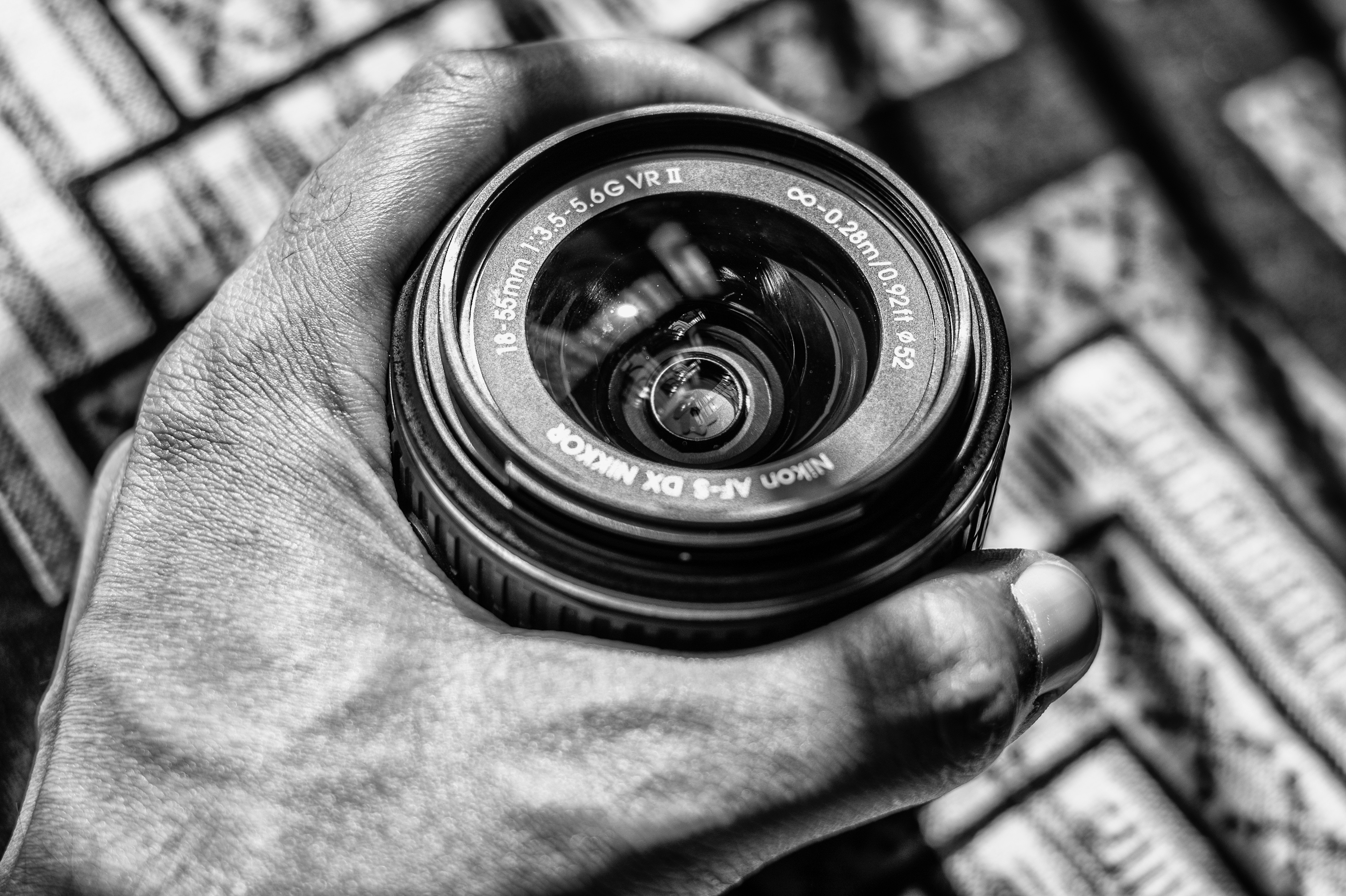 Grayscale photography of person holding dslr zoom lens