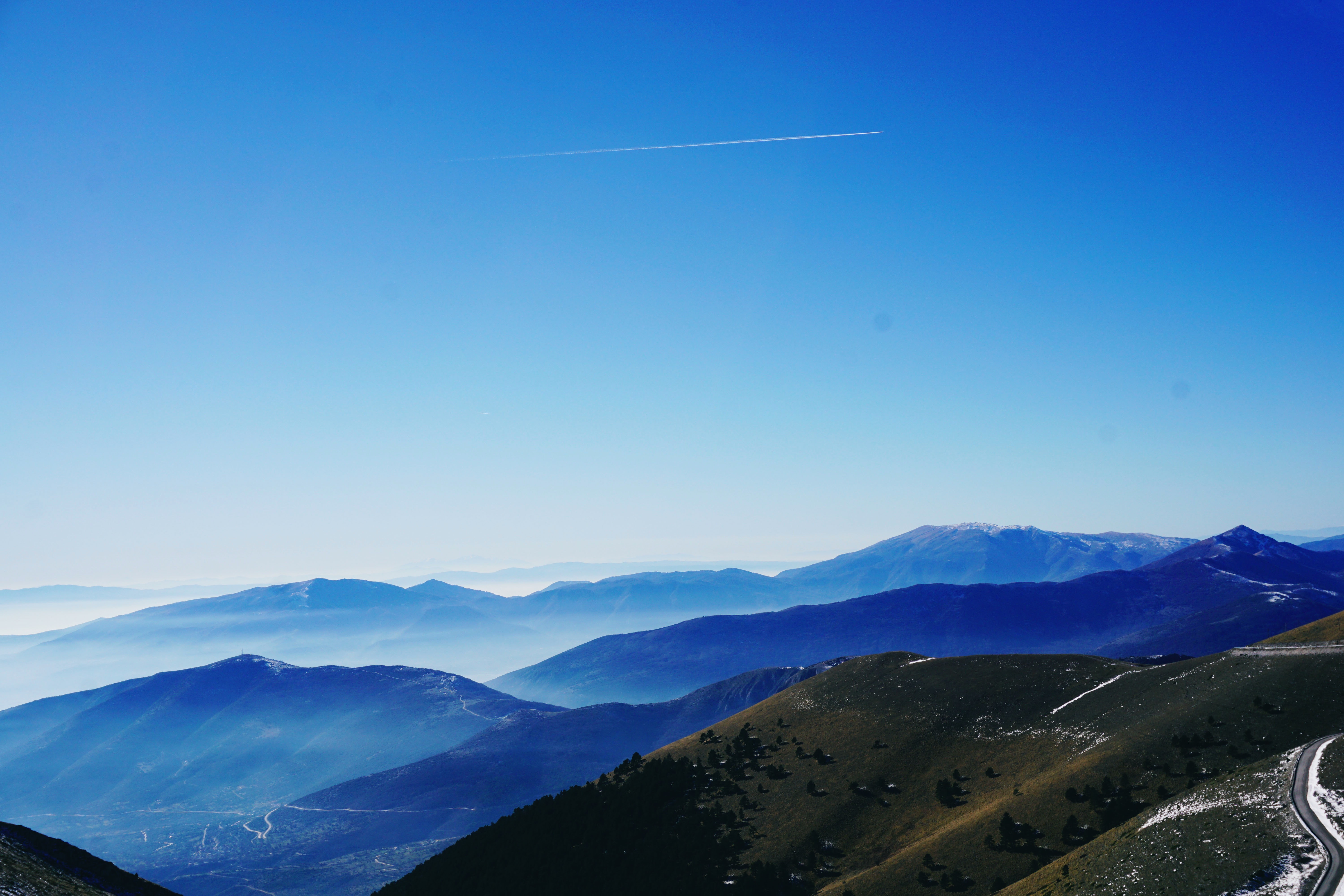 Green and blue fog covered mountains under blue sky photo