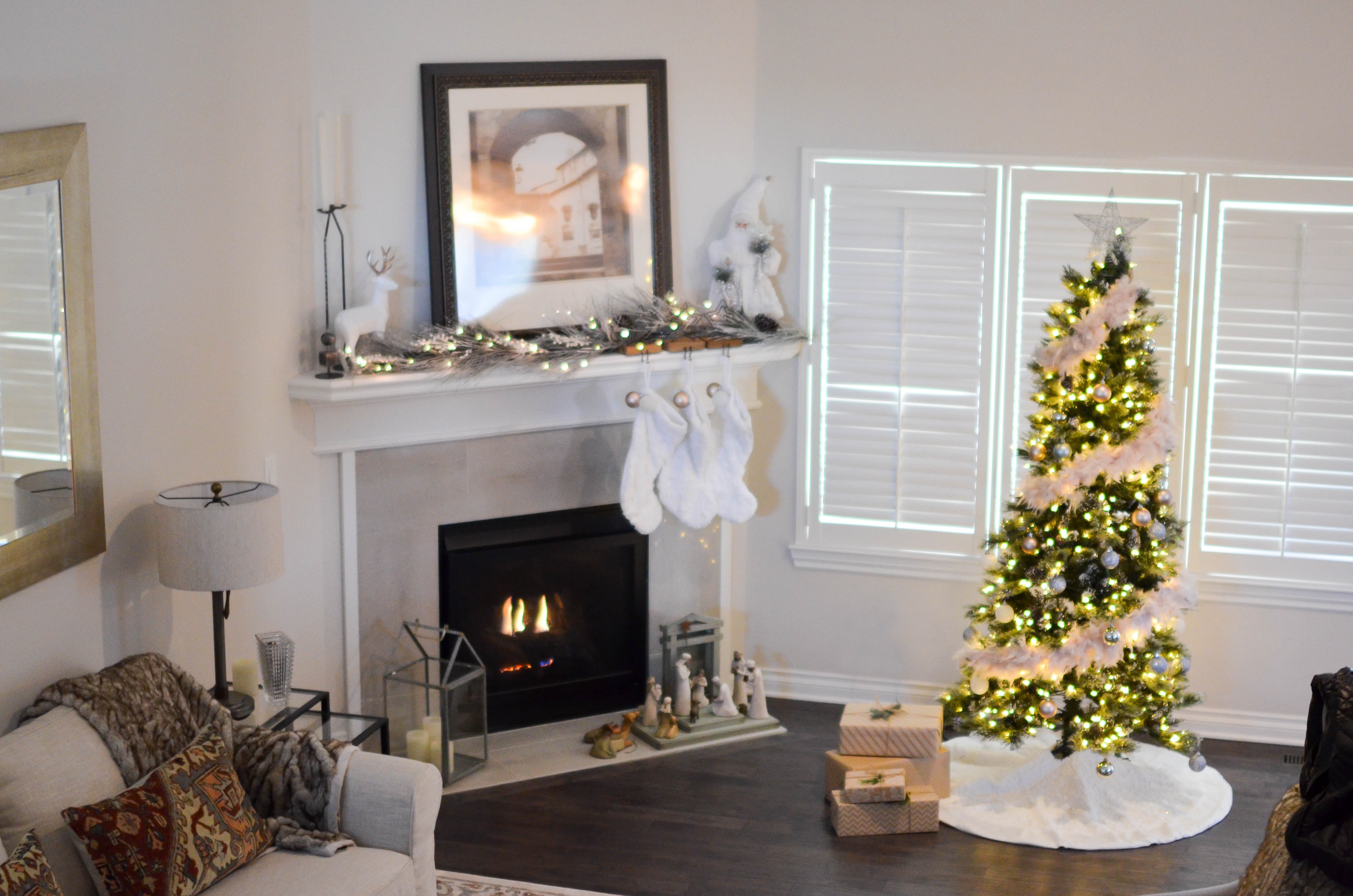 Green and white pre-lit pine tree near fireplace inside well lit room photo